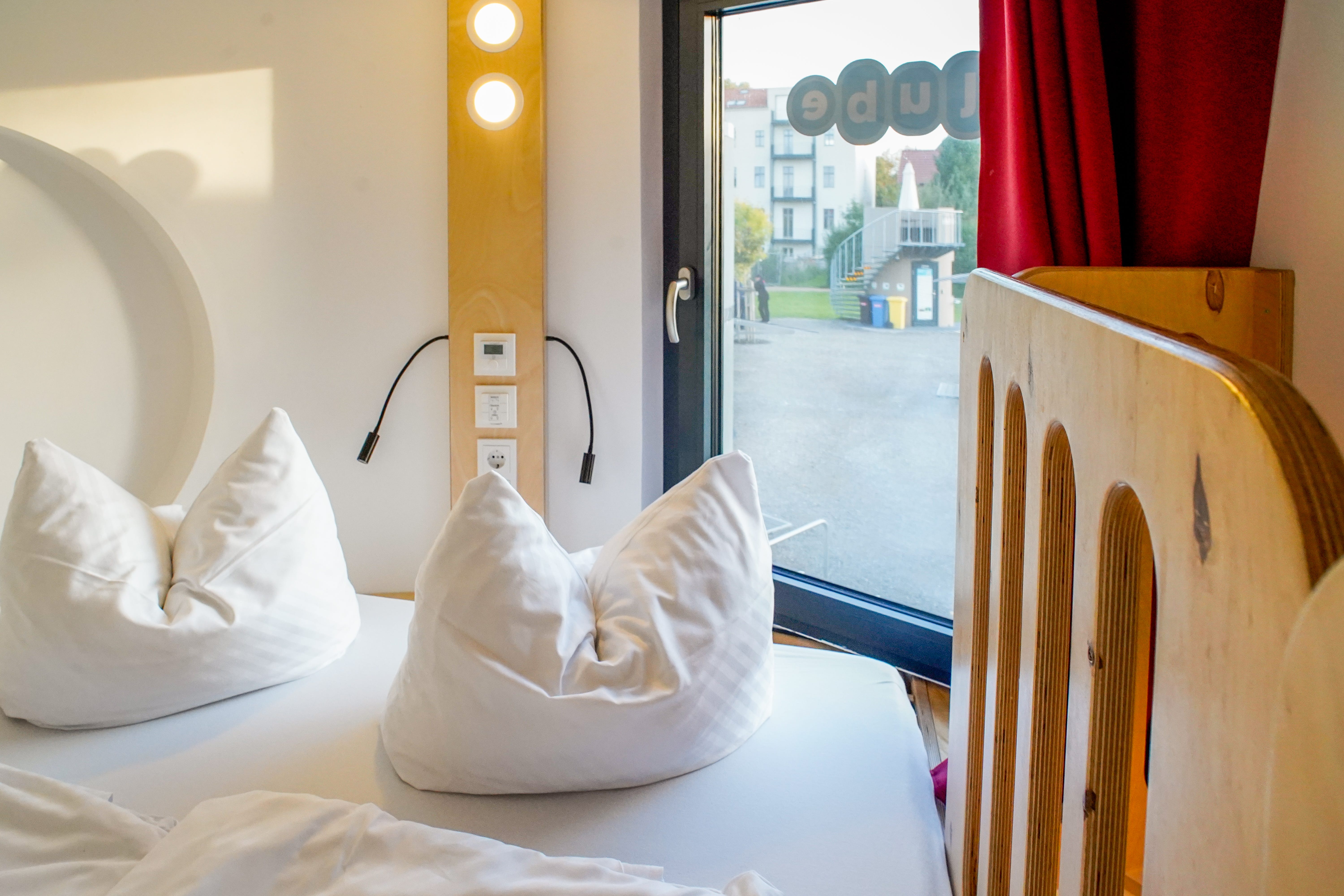 A white fenced-in bed with a window on the right