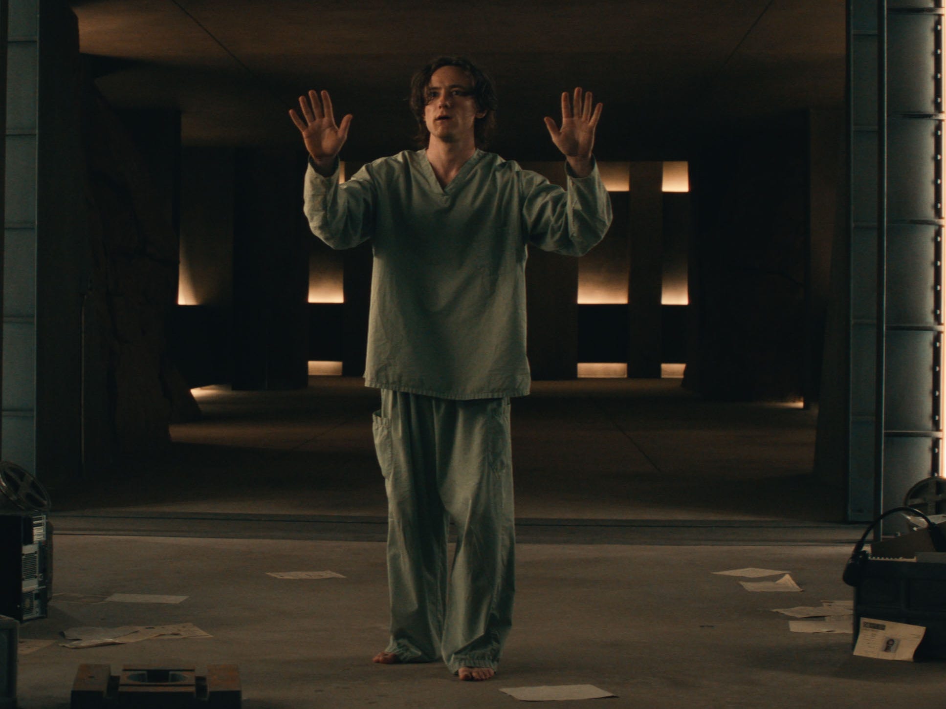 A still of "Thunderbolts*" showing a man in gray outfit with his hands up.