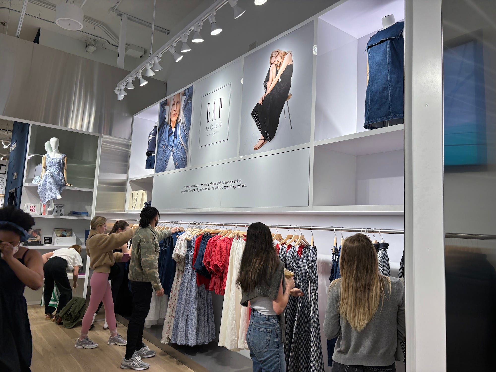 Shoppers examine clothes under a sign that says Gap x Doen.