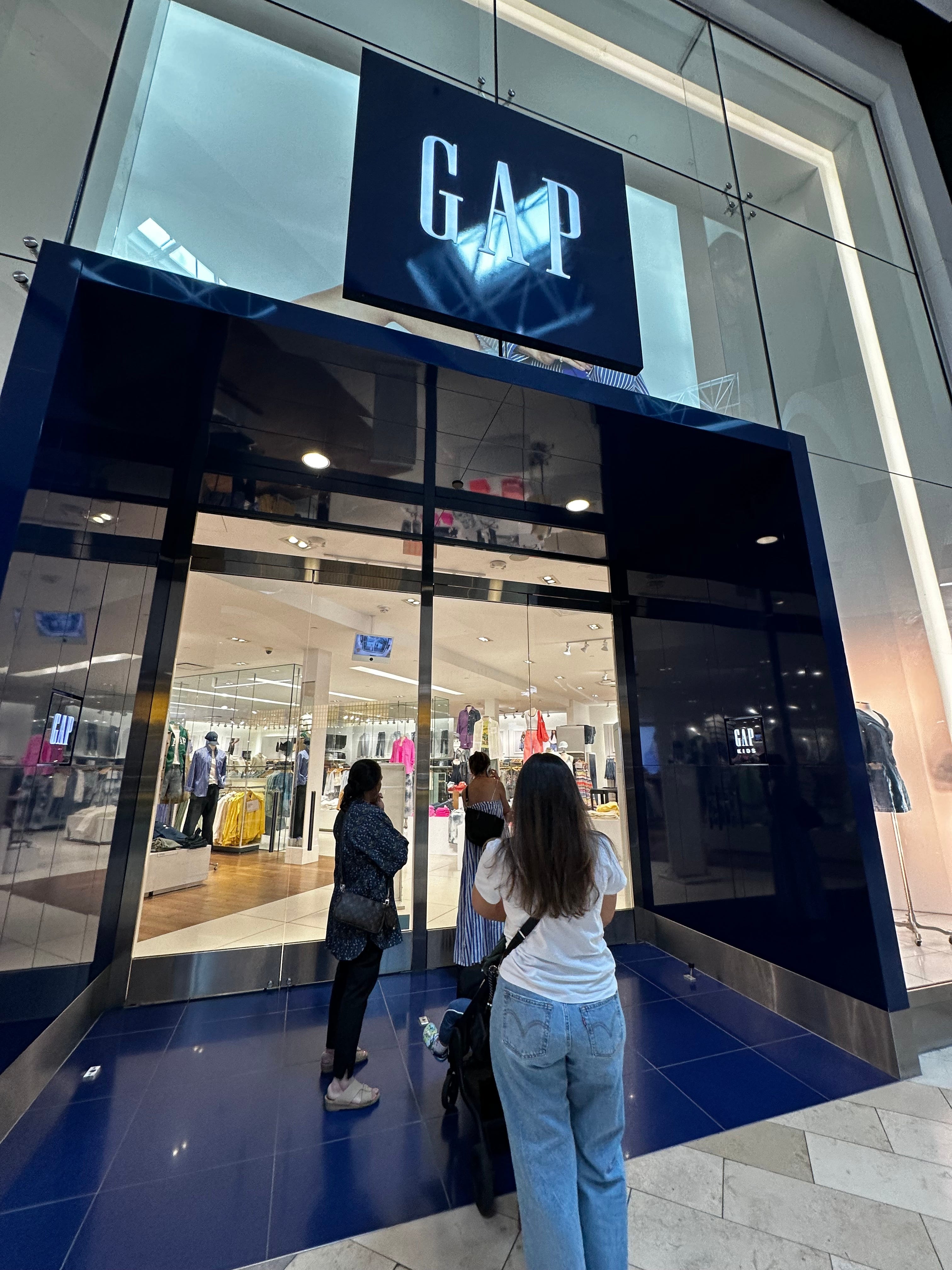 Three women wait to enter a Gap store in Paramus, New Jersey, to shop the Dôen x Gap line.