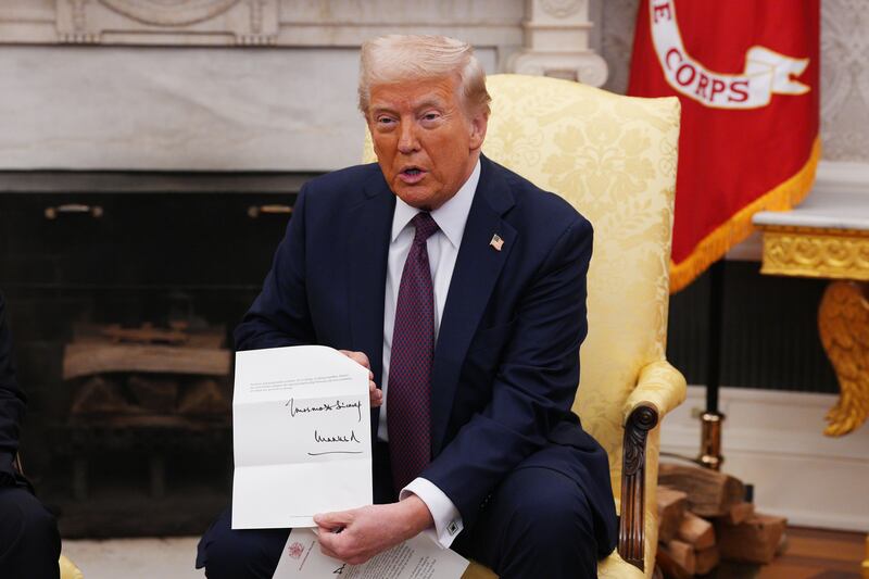 President Trump showing off an invitation from King Charles during a visit by British Prime Minister Keir Starmer to the White House.