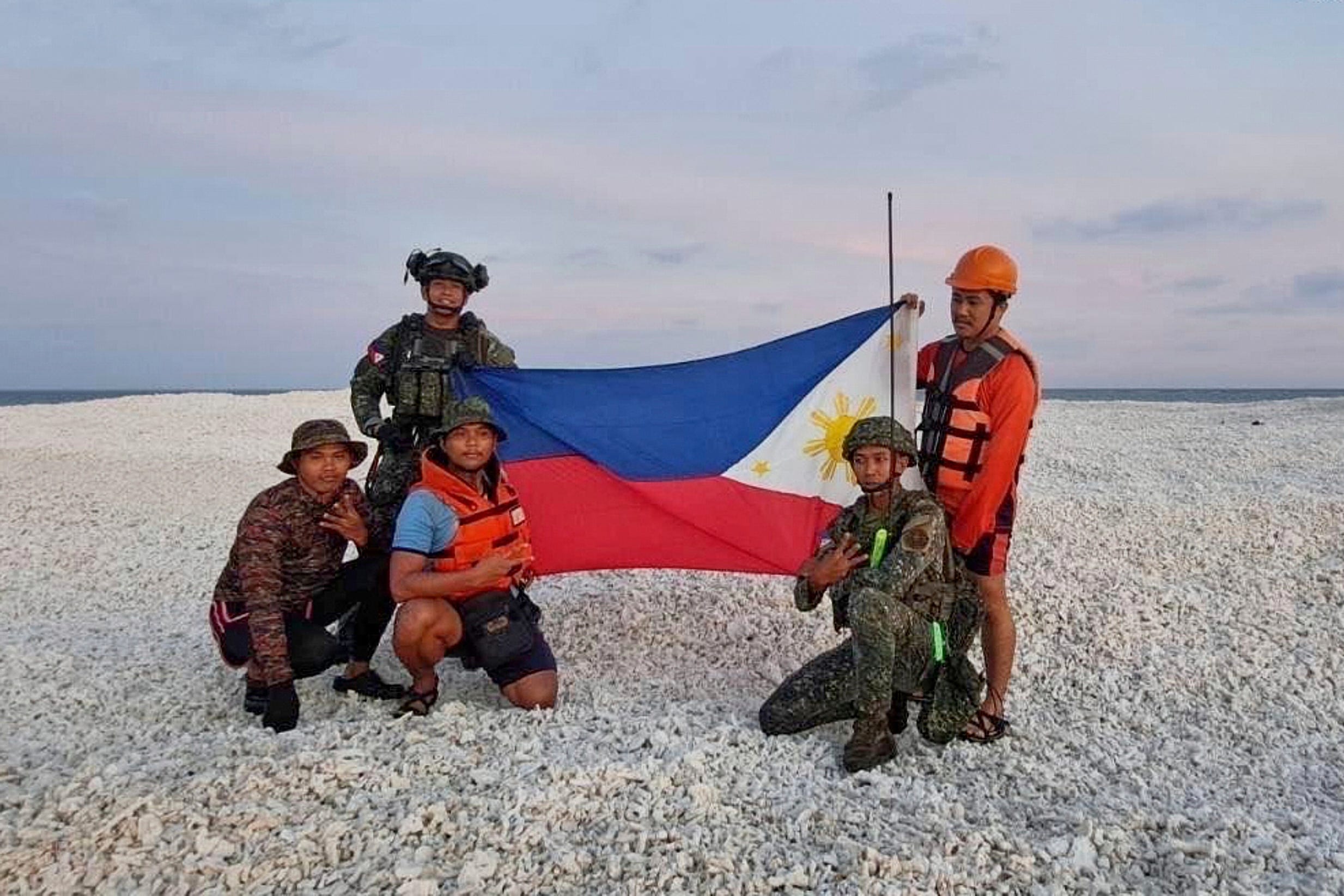 The Philippines coast guard holding national flag on Sandy Cay