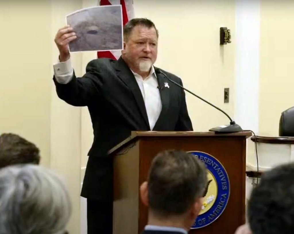 Luis Elizondo holds up the photograph of the purported UAP (Unidentified Anomalous Phenomena) at the hearing on Thursday (1 May 2025).