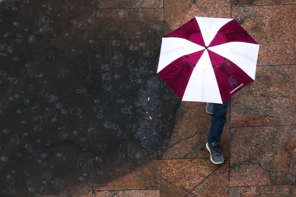 Person walking with an umbrella in the rain in Manhattan, New York City on March 24, 2025.