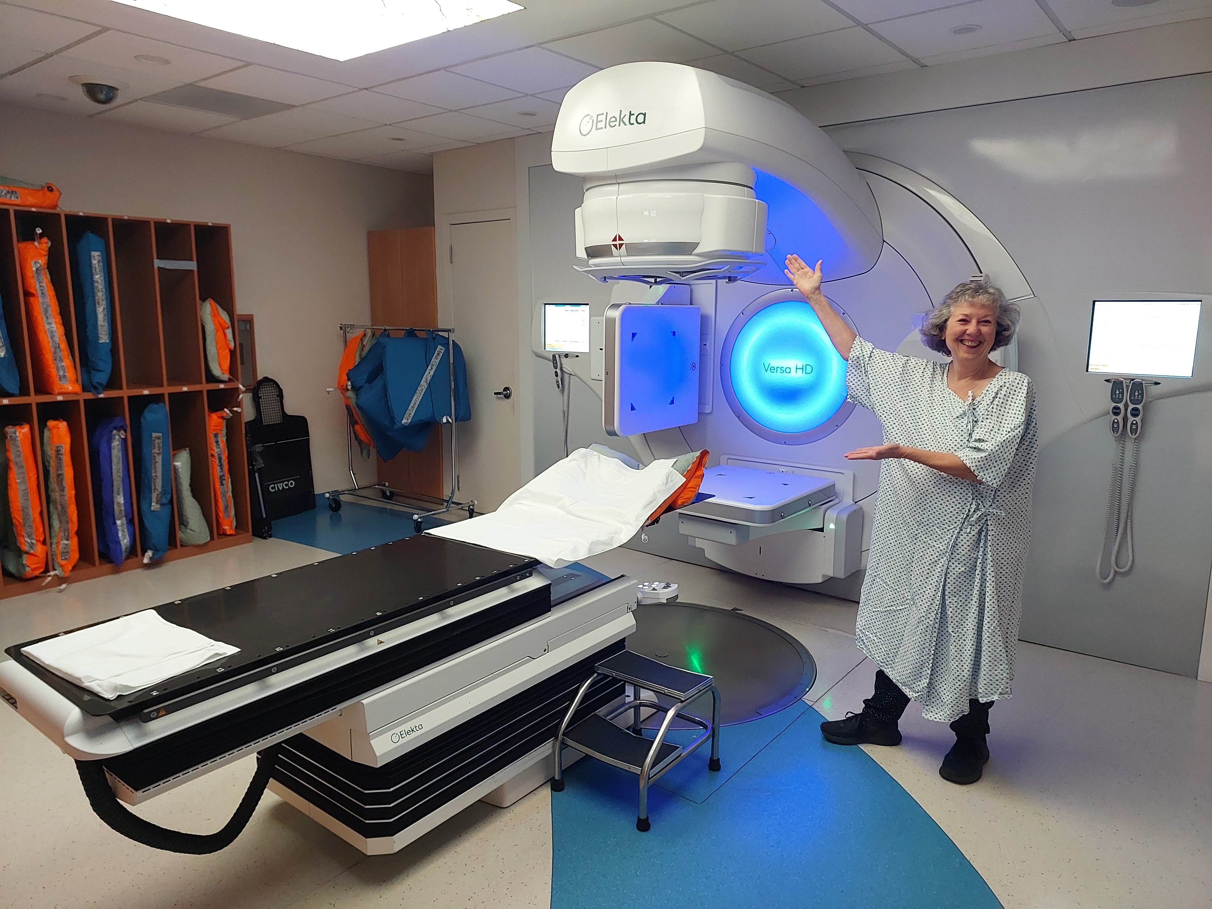 woman in a hospital gown with a radiation machine