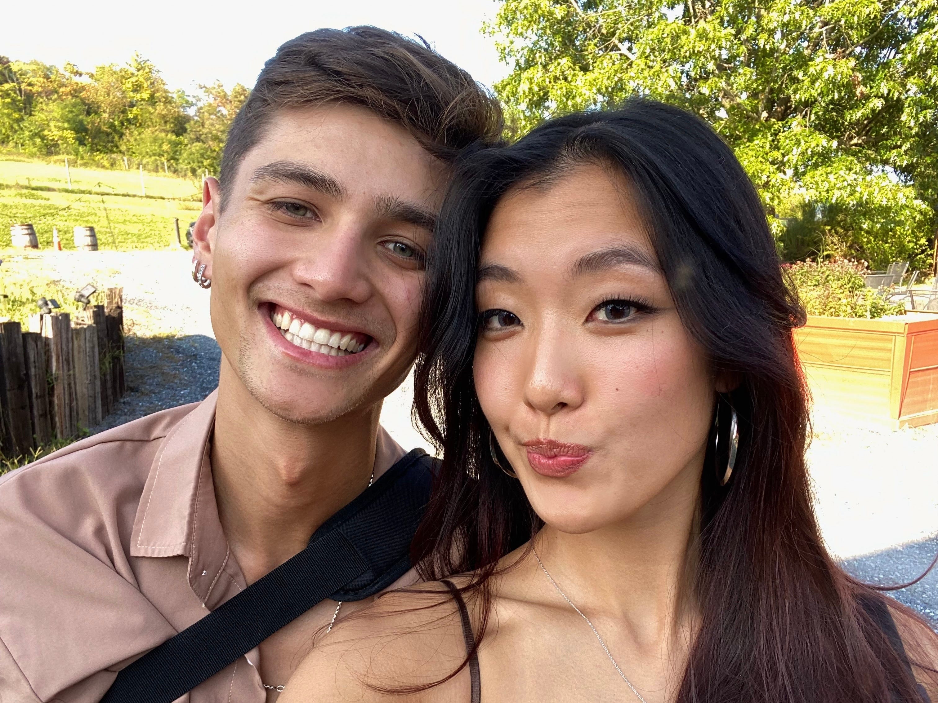 The author and her boyfriend smiling outside on a sunny day.