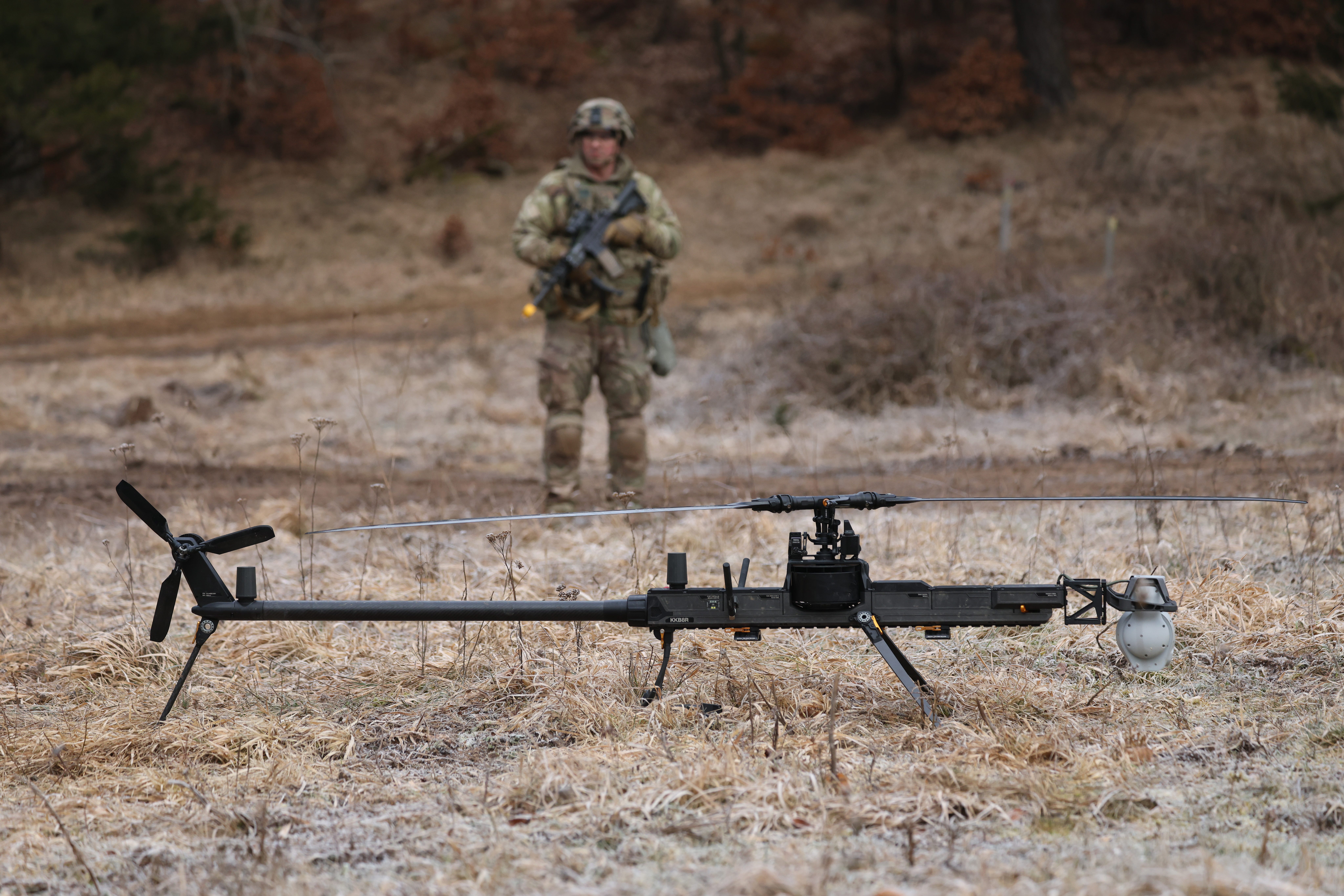 A US Army drone operator stands near an Anduril Ghost-X helicopter surveillance drone.