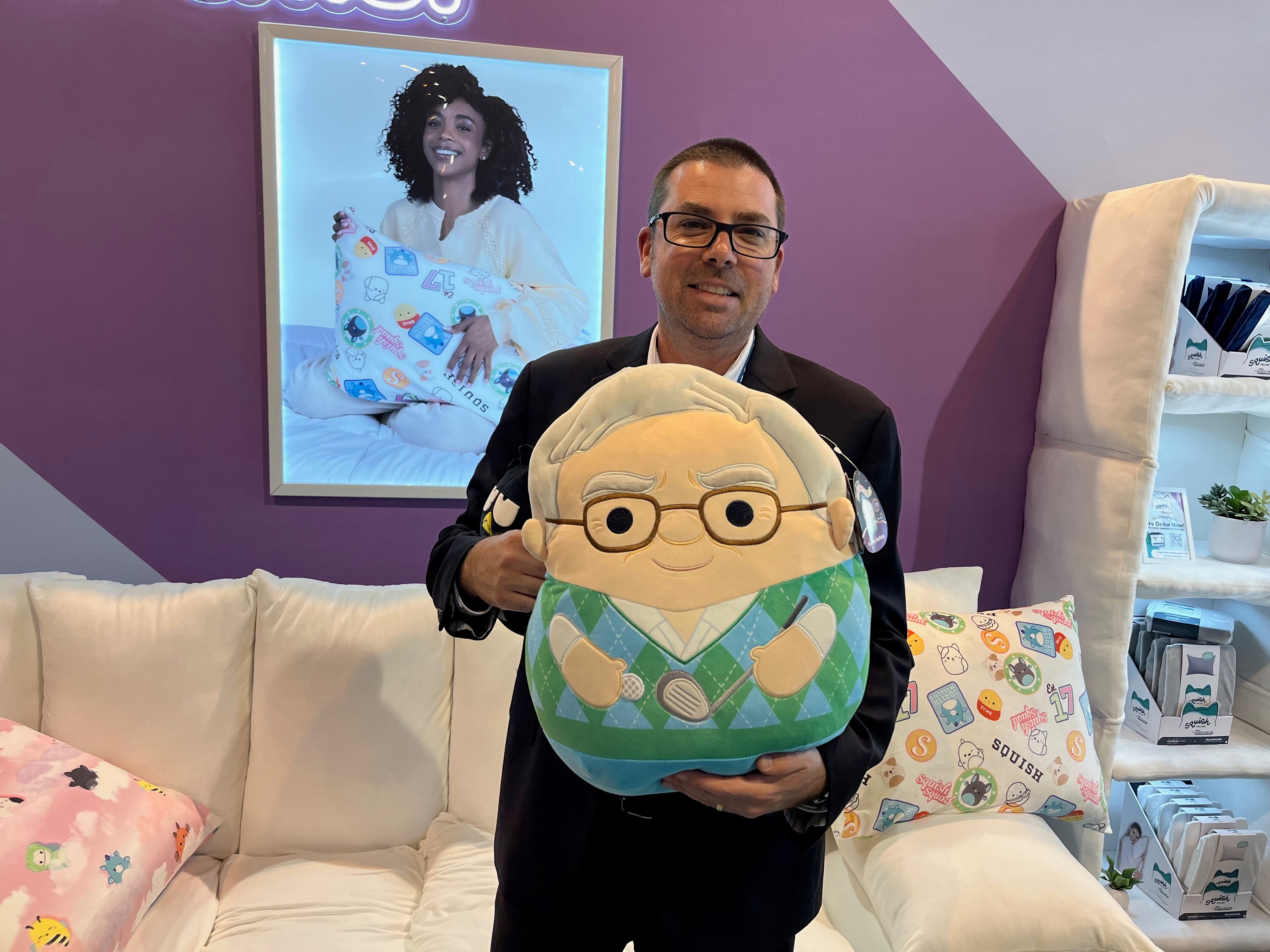 A Jazwares employee holding a Warren Buffett plushie.