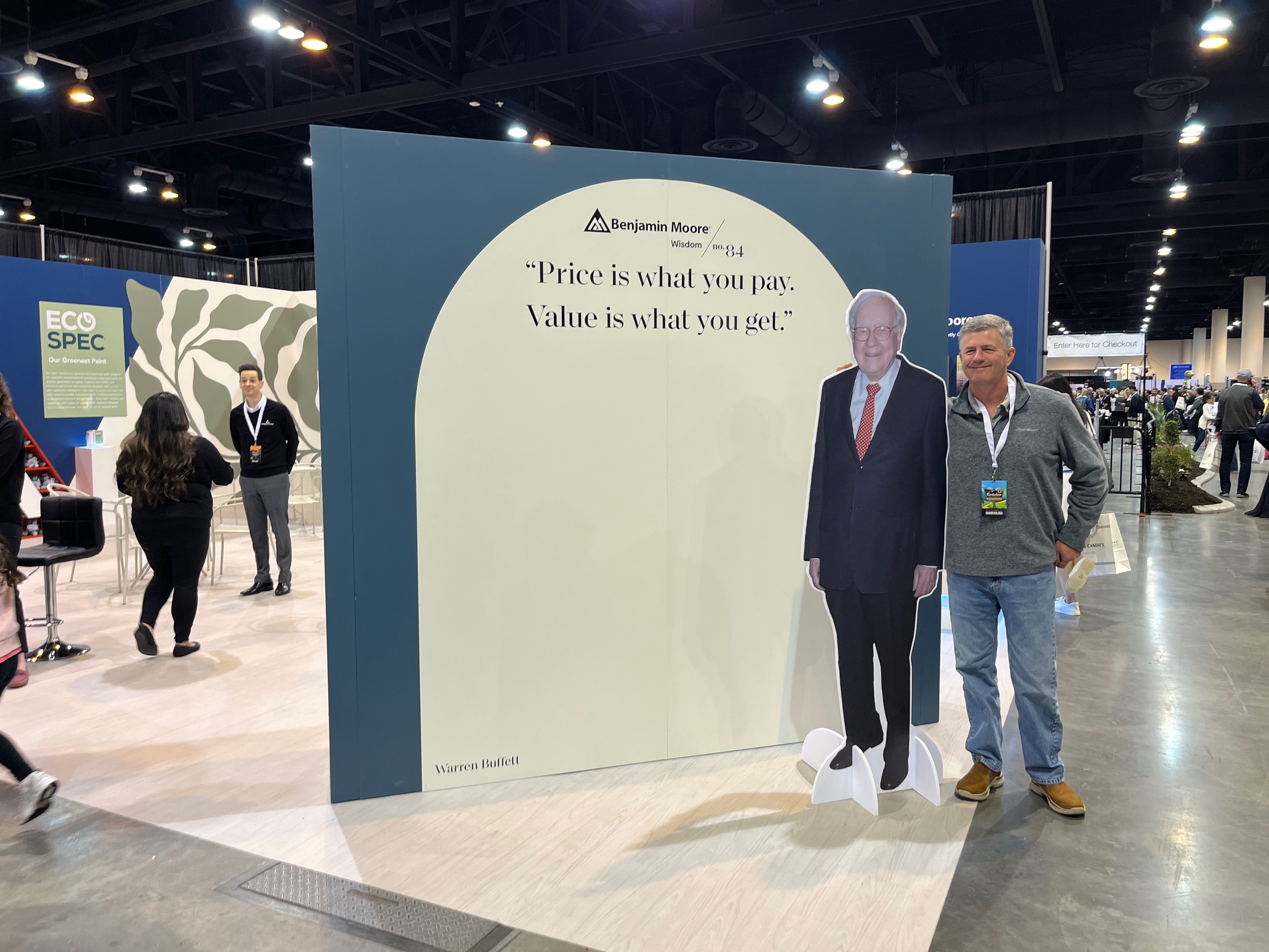 A shareholder poses with a cardboard cutout of Warren Buffett.