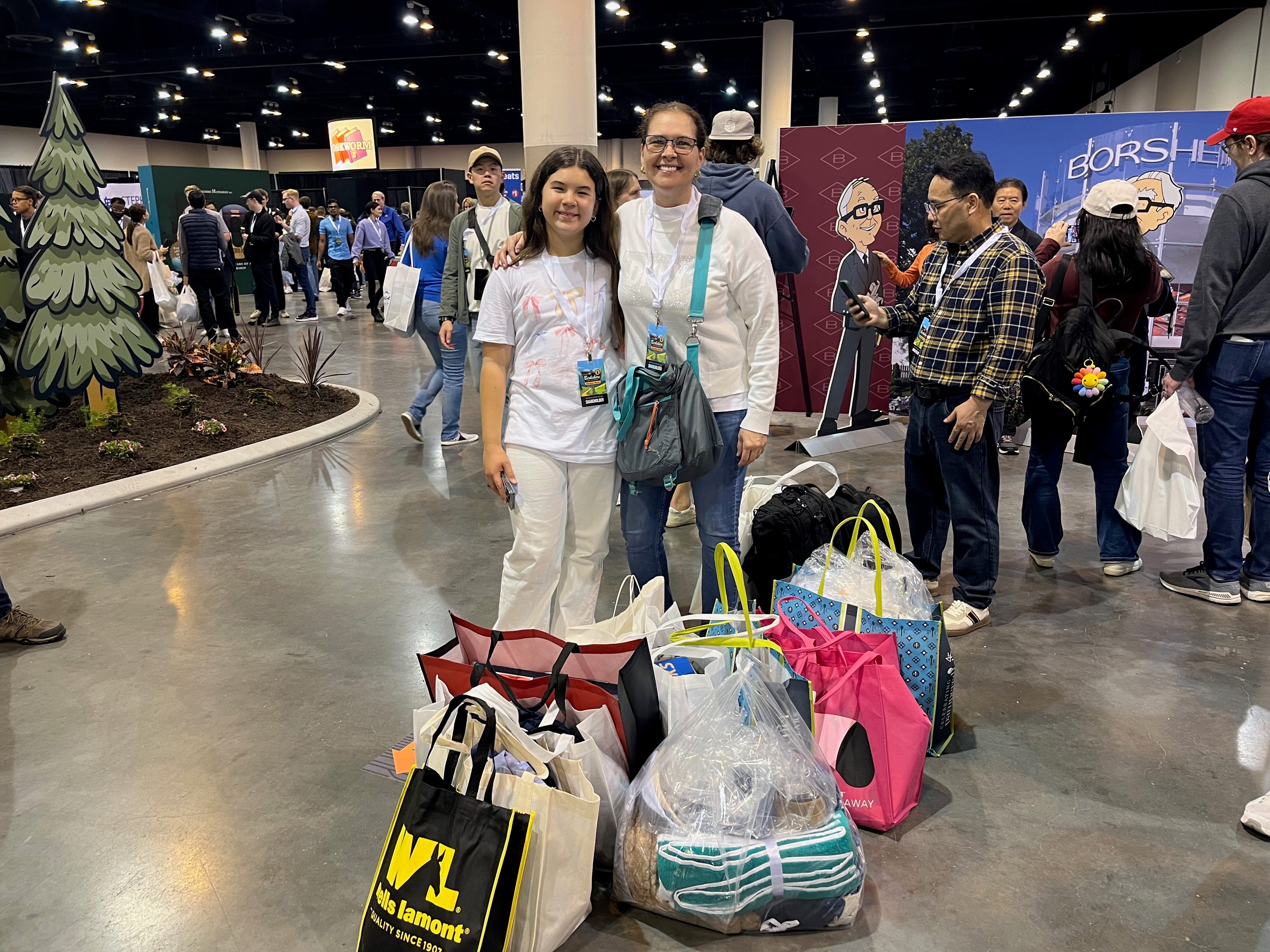 Two shoppers posing with lots of bags.