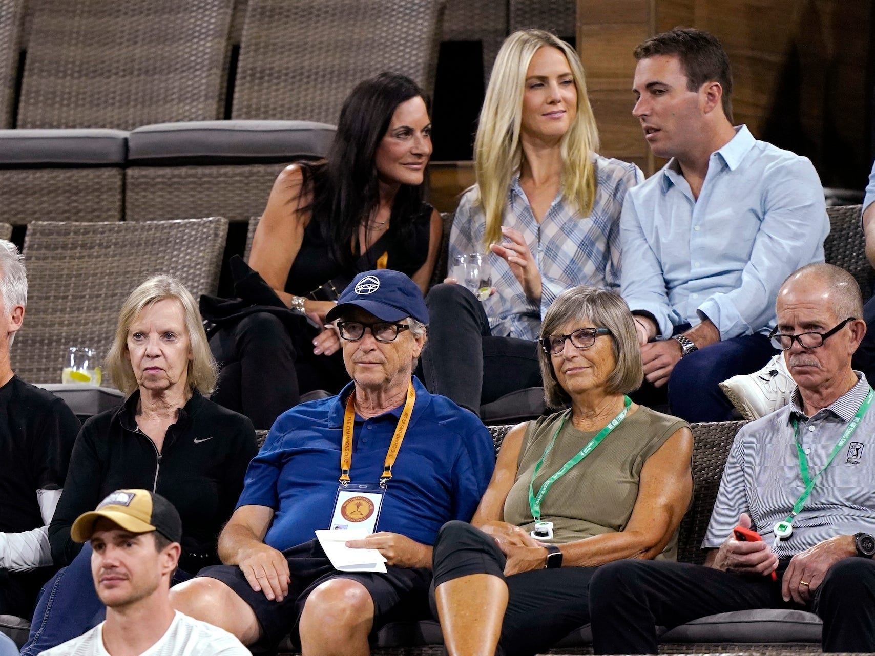Bill Gates and Paula Hurd, seated in different rows, at a tennis tournament.