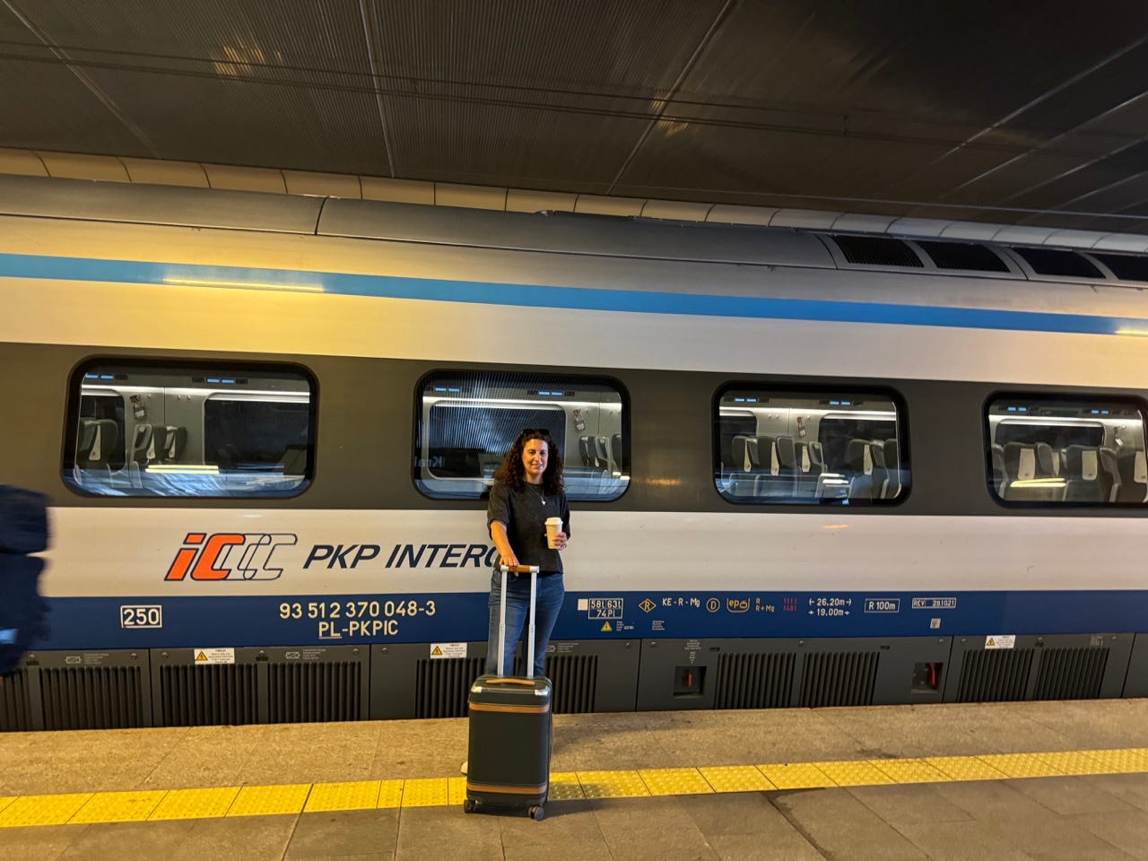 Author Jamie Davis Smith with suitcase near train in Poland