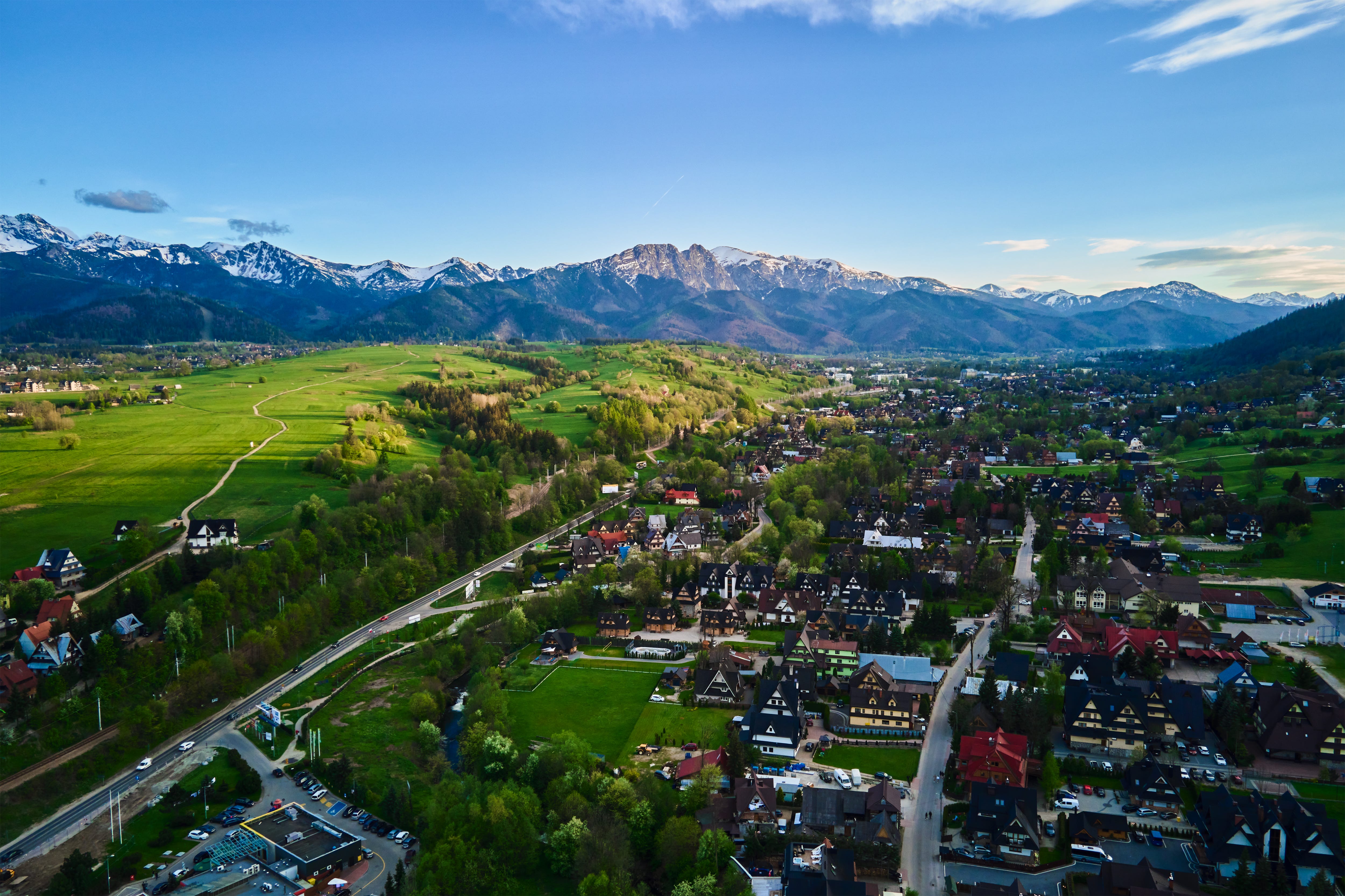 Aerial view of Zakopane with green hills, mountains, colorful houses
