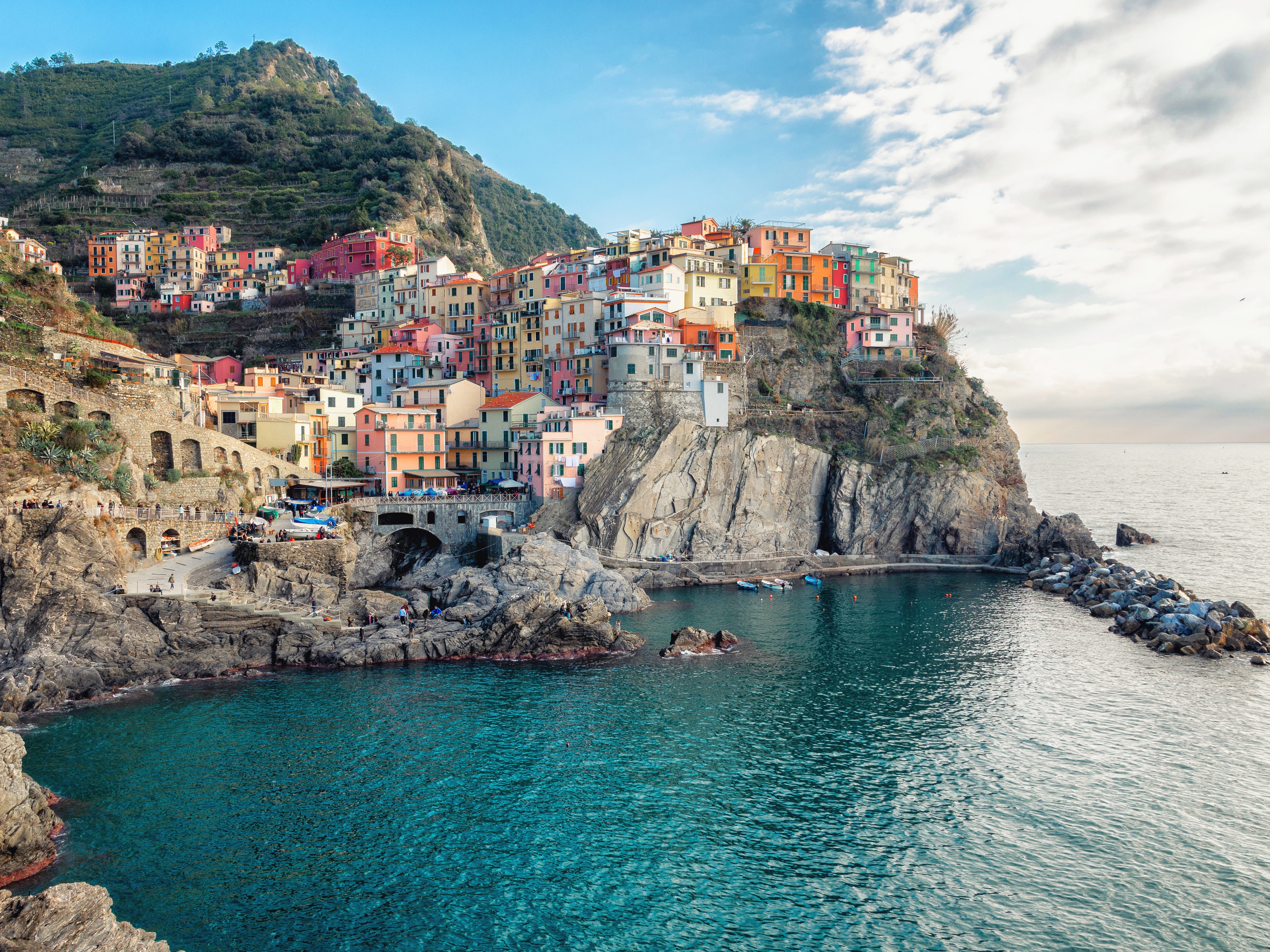A cliffside town with colorful buildings overlooking the turquoise water.
