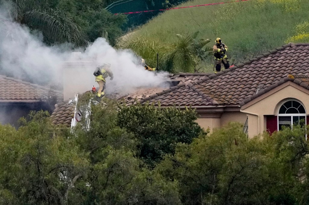 Firefighters work at the site of a plane crash in the Wood Ranch section of Simi Valley, Calif., on Saturday, May 3, 2025.