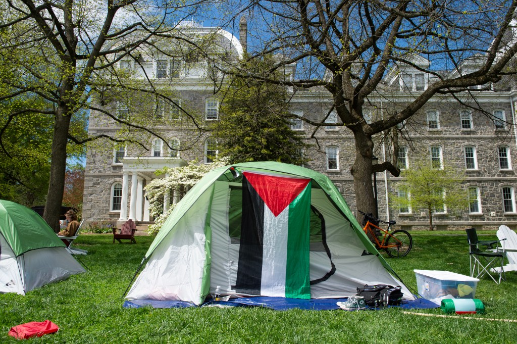 Tent with Palestinian flag in front of a college building 
