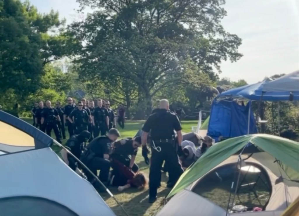 Police officers disbanding a pro-Palestinian encampment at Swarthmore College, arresting nine individuals, and protestors being pinned on the ground