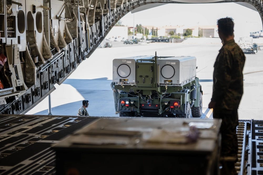 A US Marine guides a NMESIS out of the cargo bay of a C-130