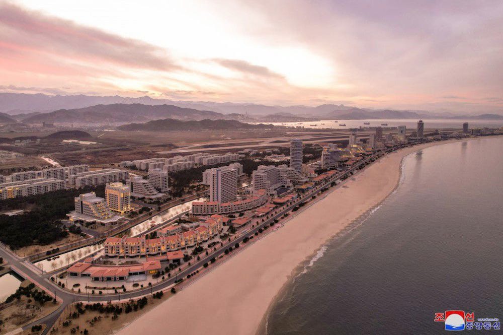 An aerial photograph of a stretch of beach at Wonsan Kalma tourist resort, North Korea, including multiple hotel and apartment buildings, in rosy light. Image shared by state-controlled media.