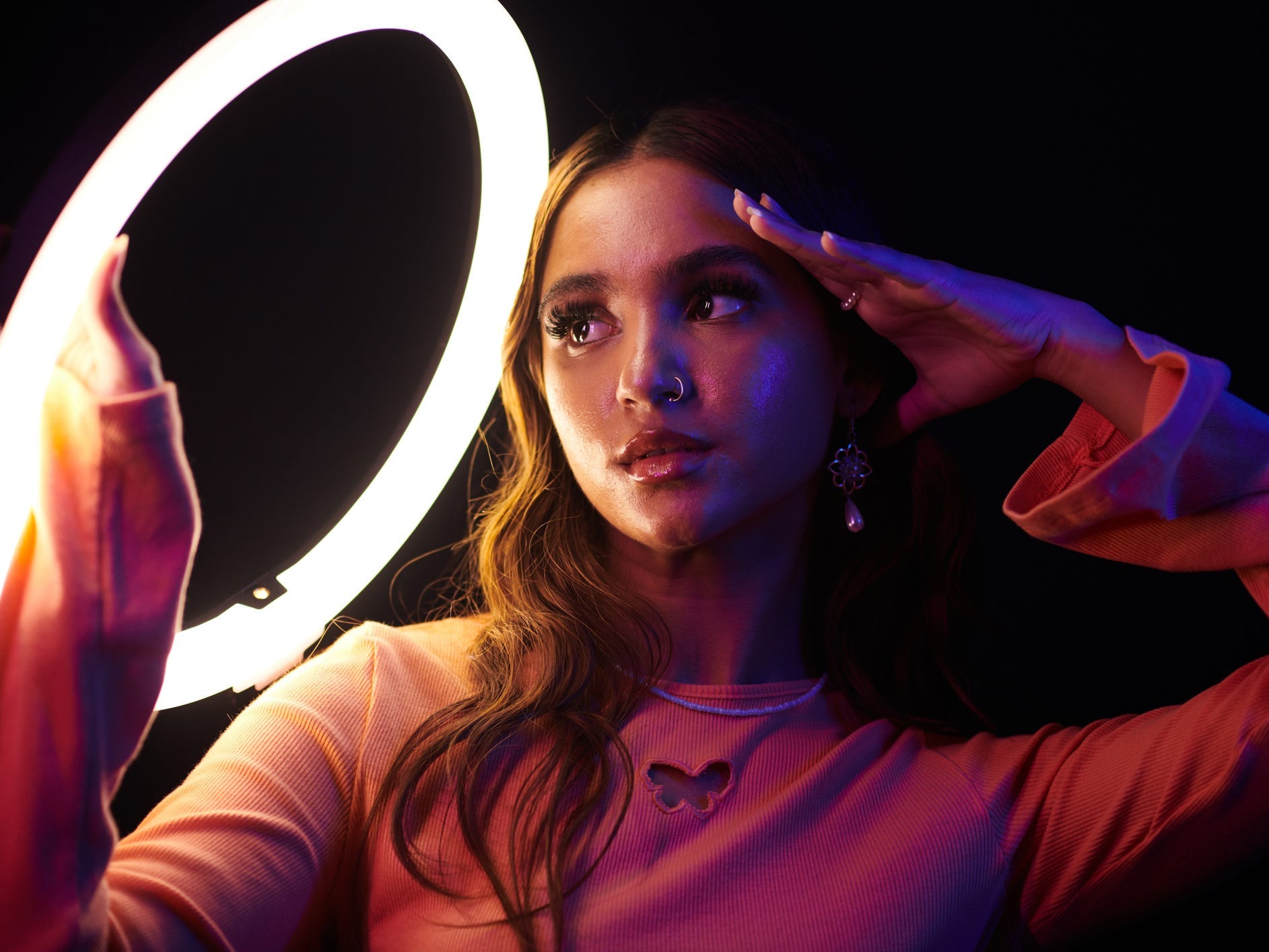 A young woman posing with a ring light