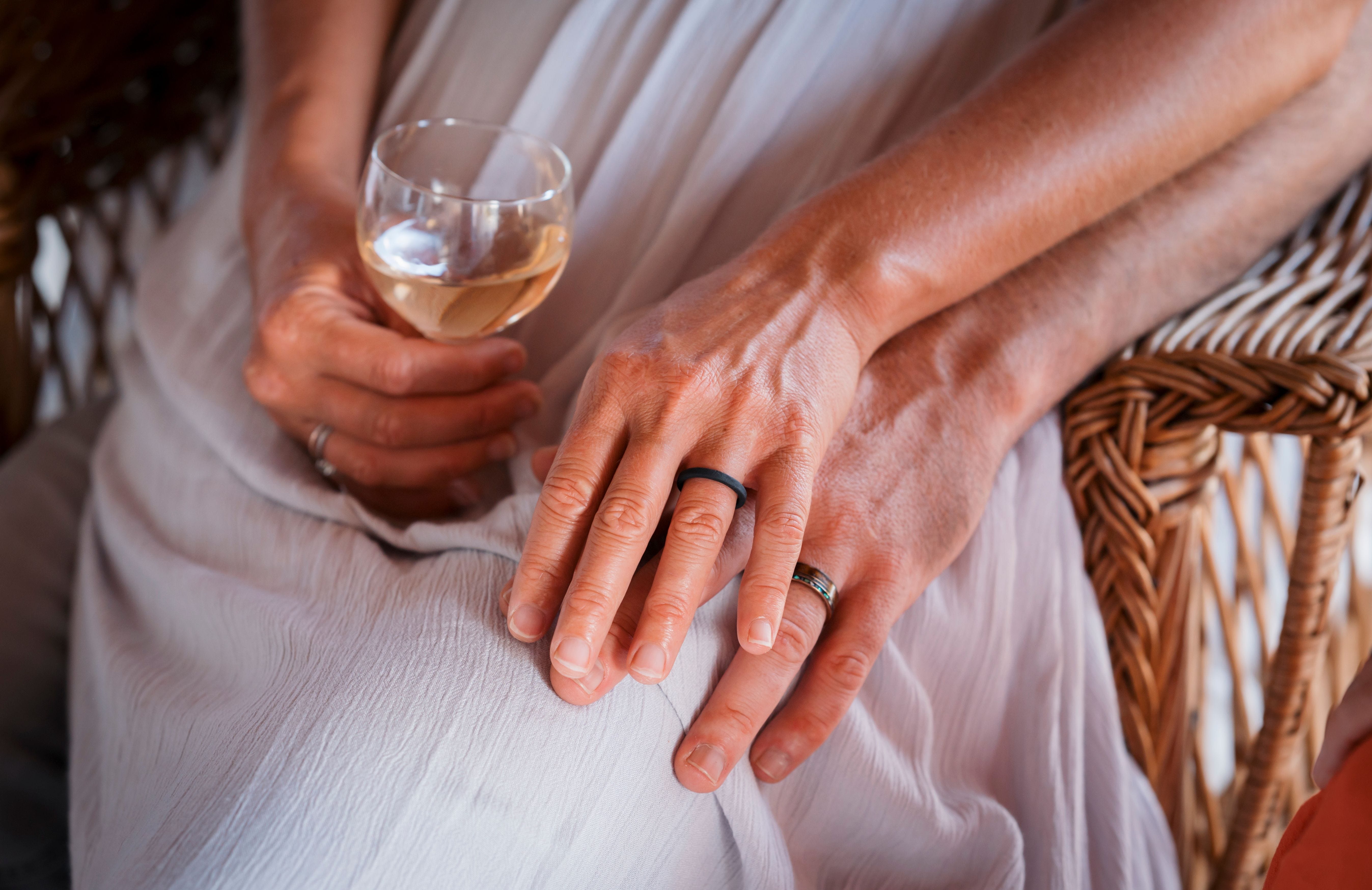 Close-up of two hands holding wearing wedding rings.