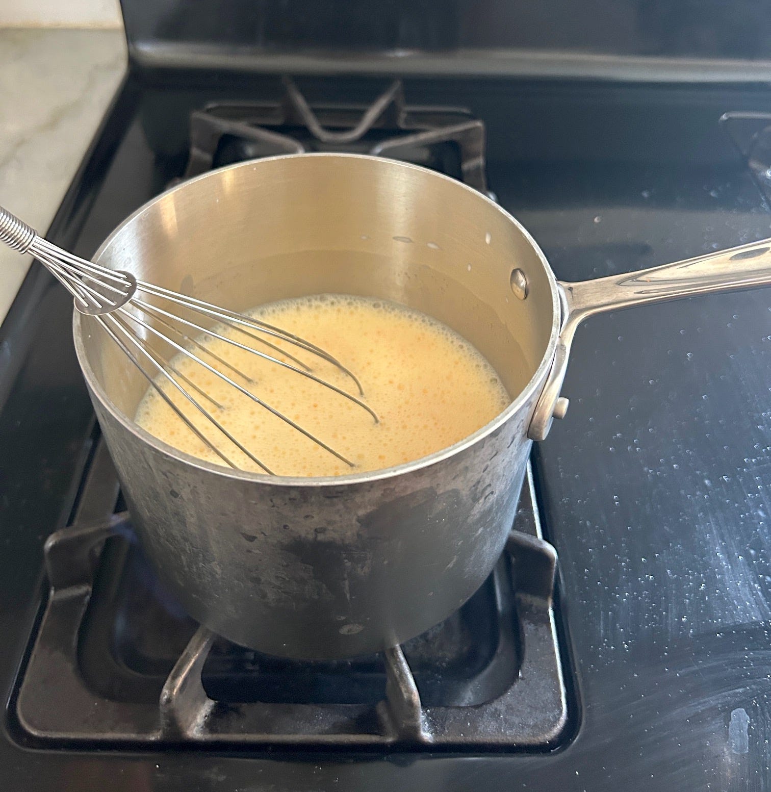 Whisking pudding on the stove for Meghan Markle's Chantilly Lily