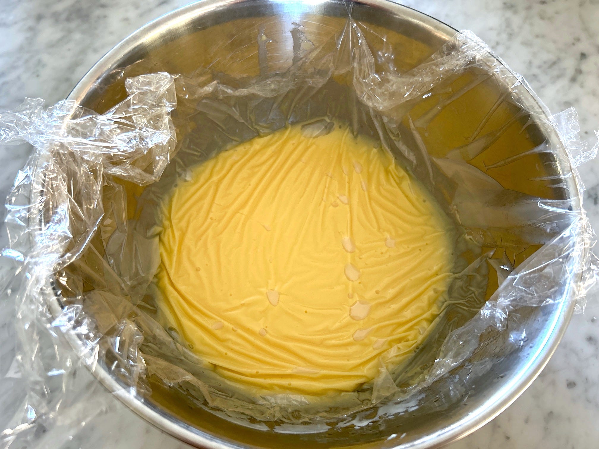 Covering the pudding with plastic wrap for Meghan Markle's Chantilly Lily