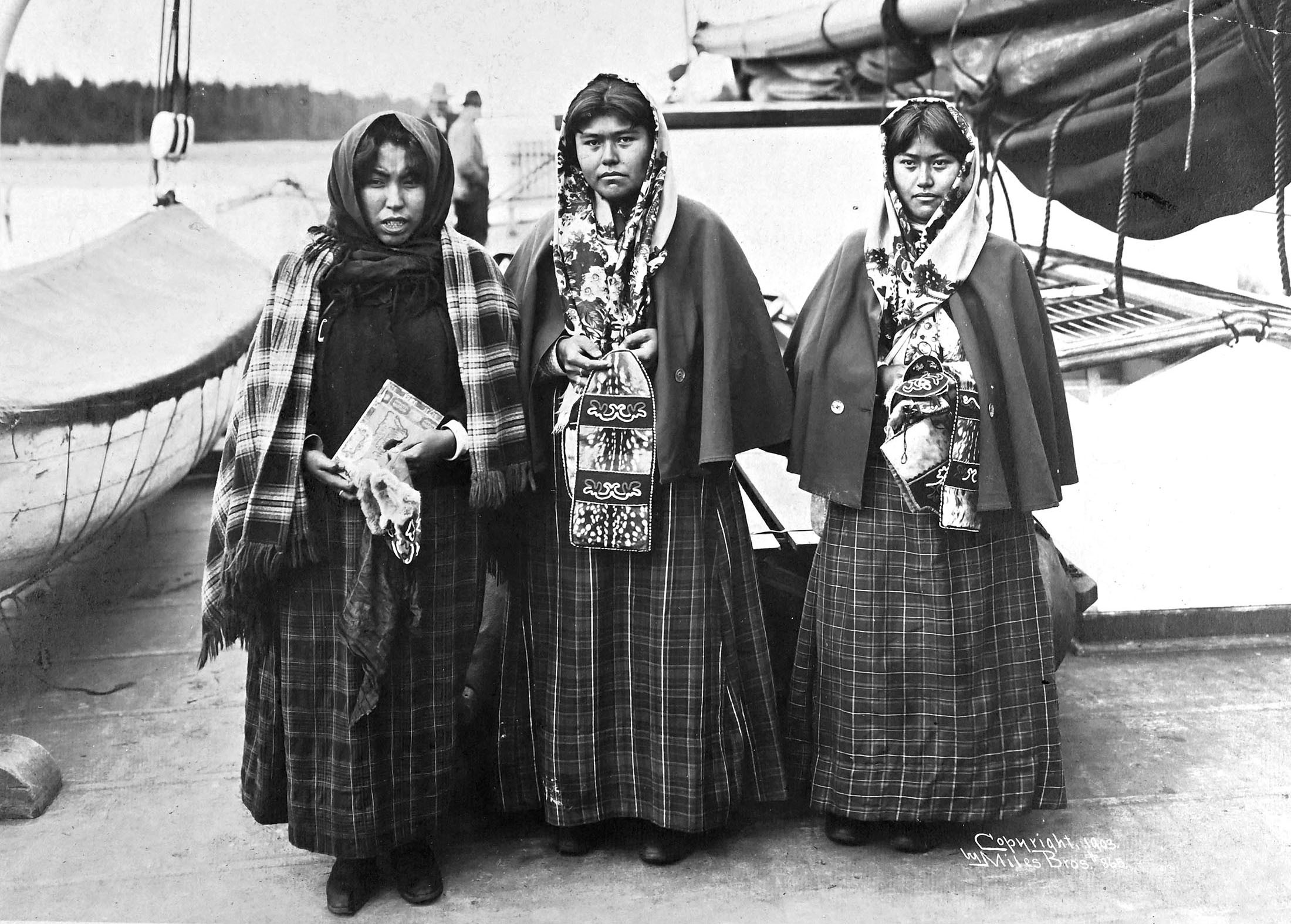 Three Alaska Natives pose aboard a steamship.
