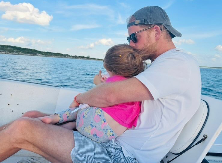 Prince Harry holding his daughter on a boat