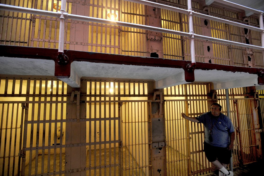 A visitor leaning against a B Block cell in the former federal prison on Alcatraz Island in the San Francisco Bay