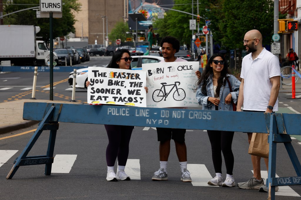 Thousands of cyclists participating in the 2025 Five Borough Bike Tour, heading towards the Pulaski Bridge, with the Queensboro Bridge in the background, and Madabusi Santanam Raghunathan among the participants, escorted by the NYPD.