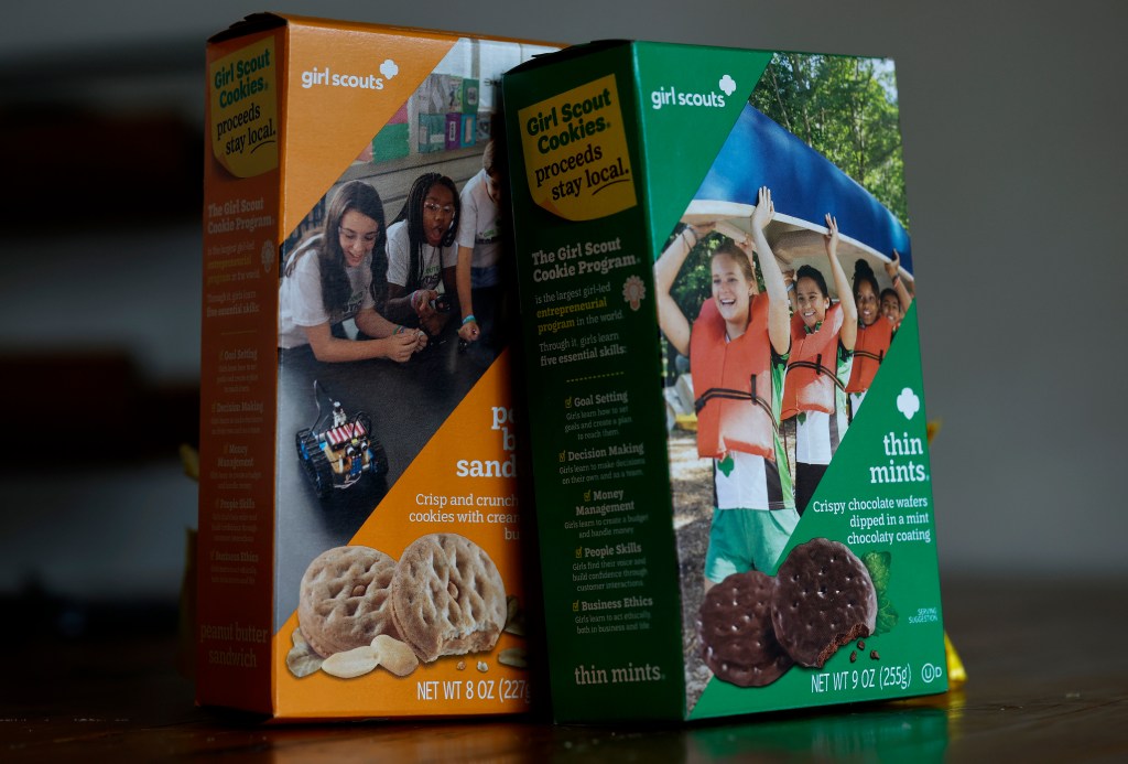 Two boxes of girl scout cookies on a table.