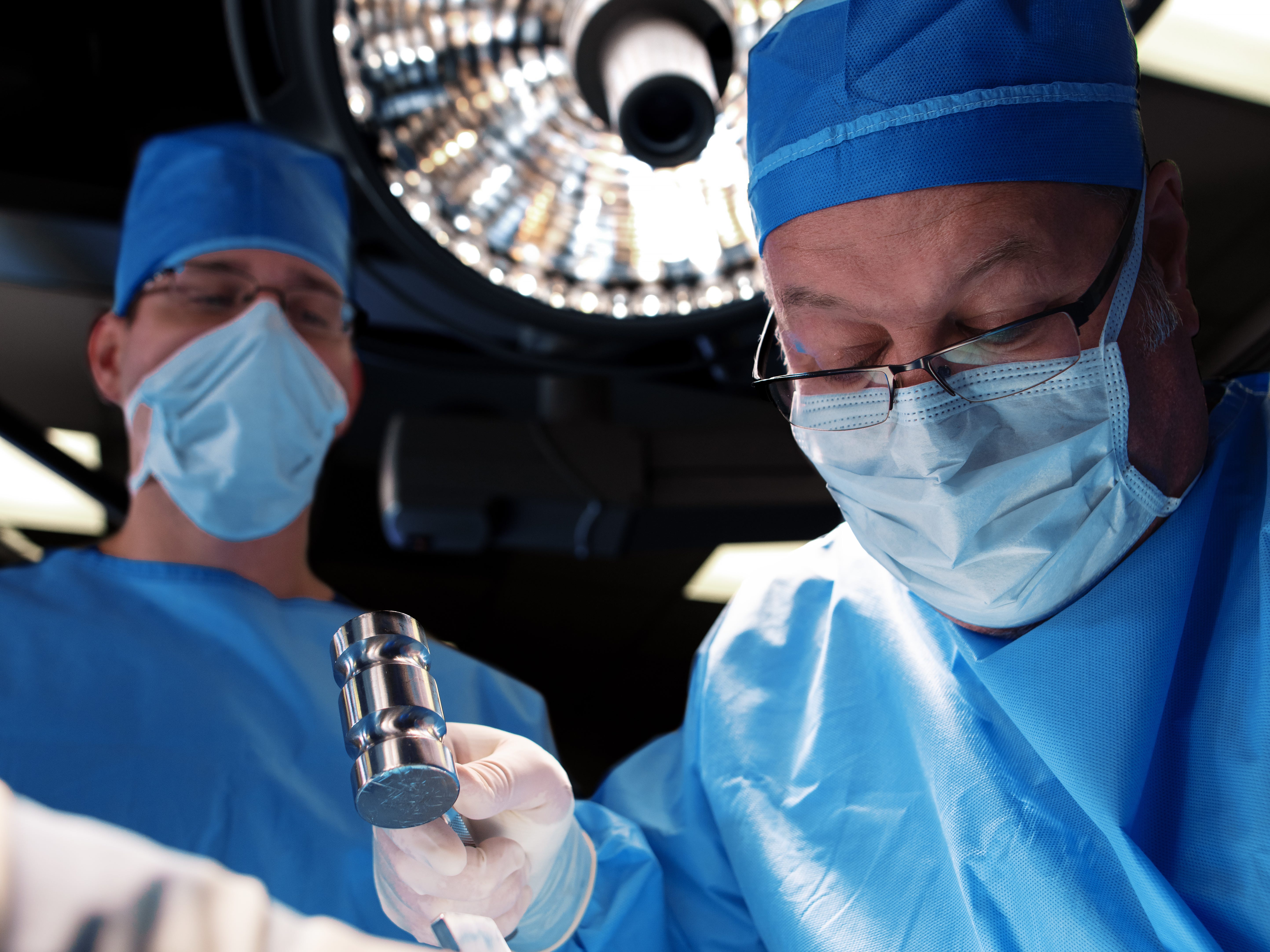 Surgeons or healthcare workers wearing face masks and blue in surgery