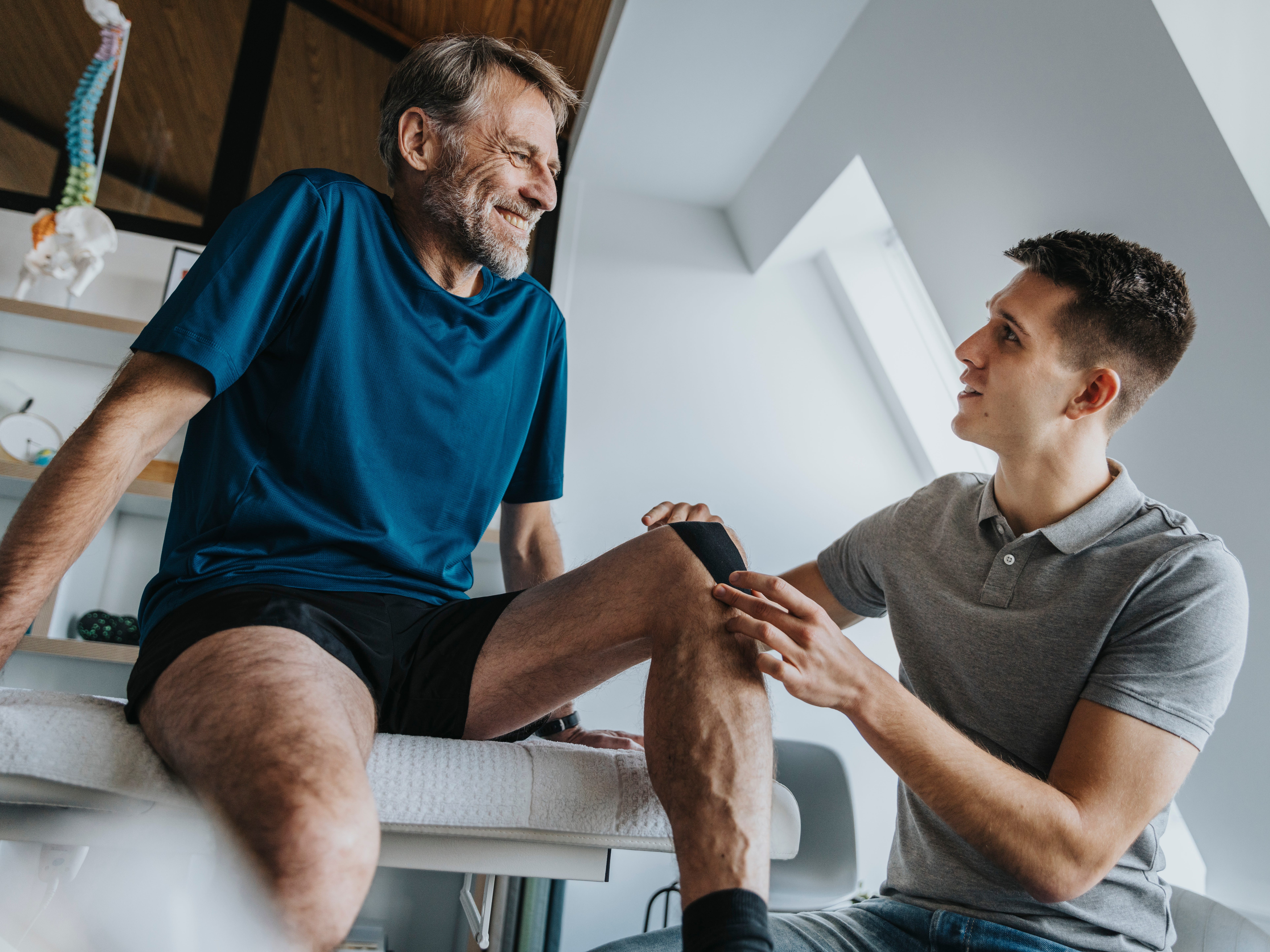 Physical therapist helping a patient with their knee