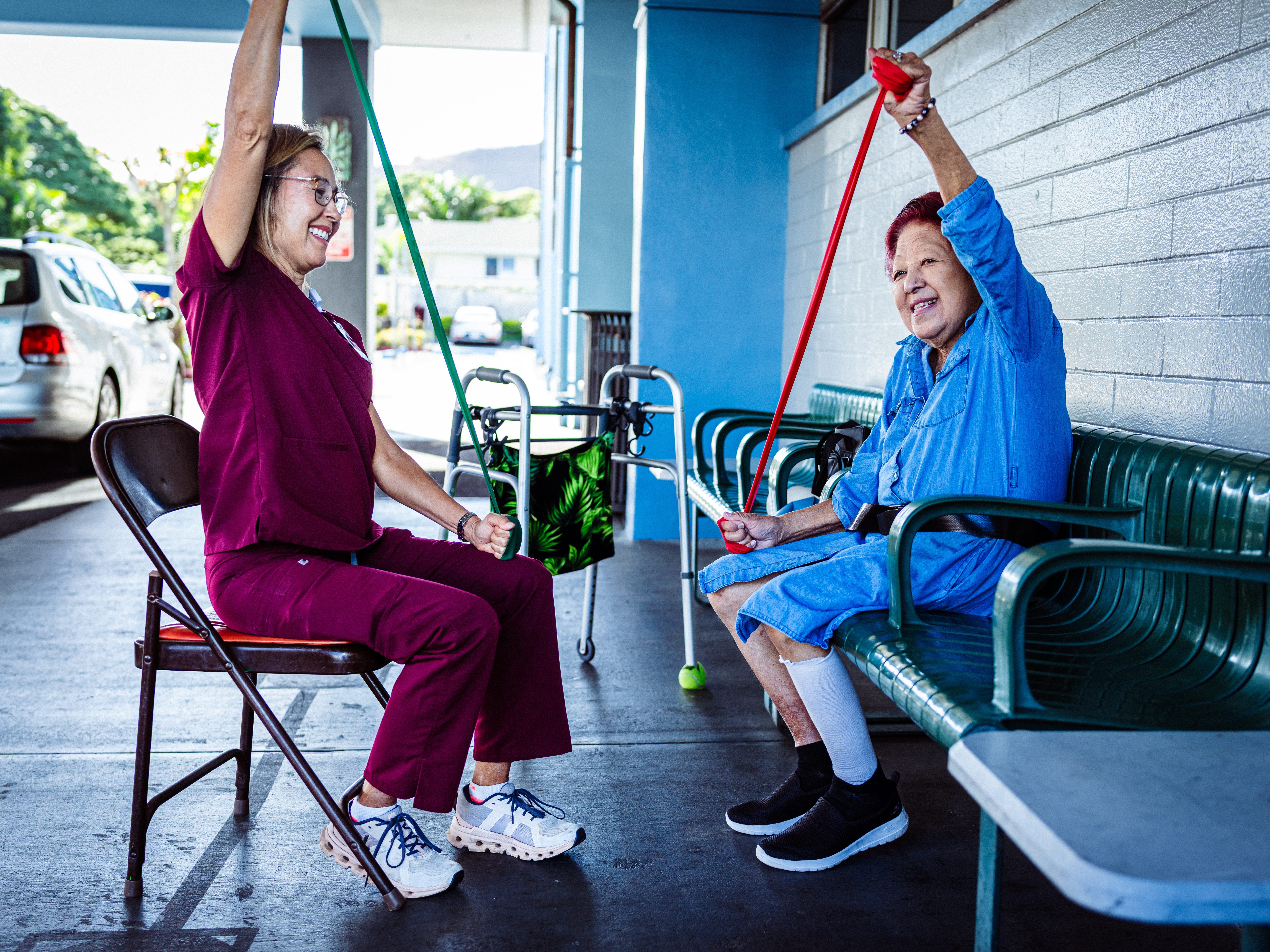 An occupational therapist or a healthcare worker and an older person using resistance bands