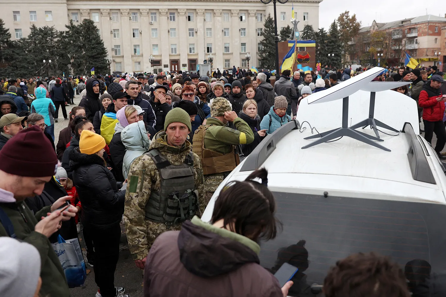 A large crowd of Ukrainians use their mobile phones standing near a Starlink satellite-based broadband station.
