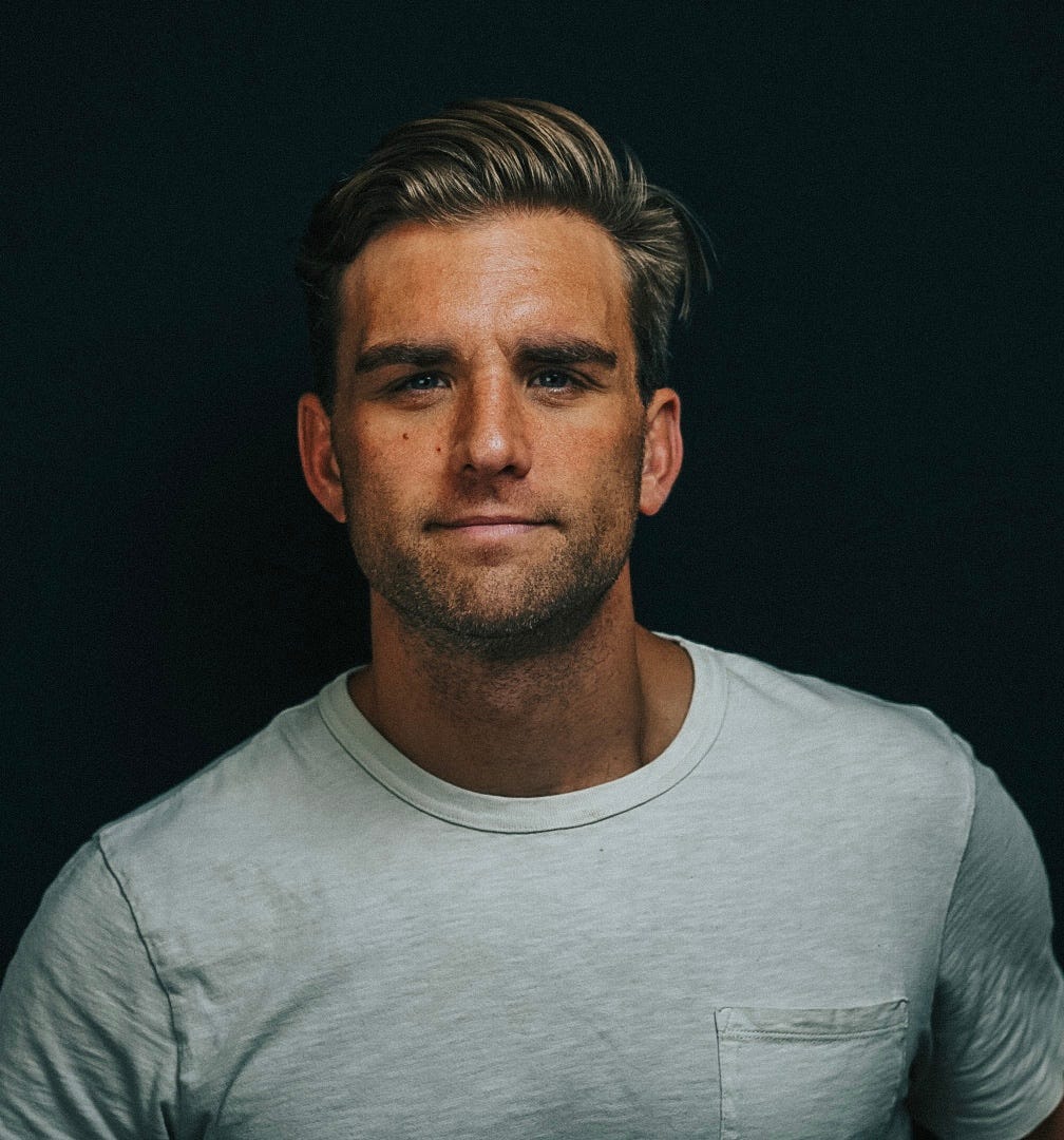 A headshot of Mike Chambers in a white t shirt