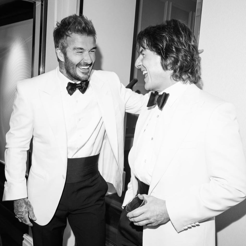 David Beckham and Tom Cruise in white tuxedo jackets, black pants, white shirts and black bow ties.