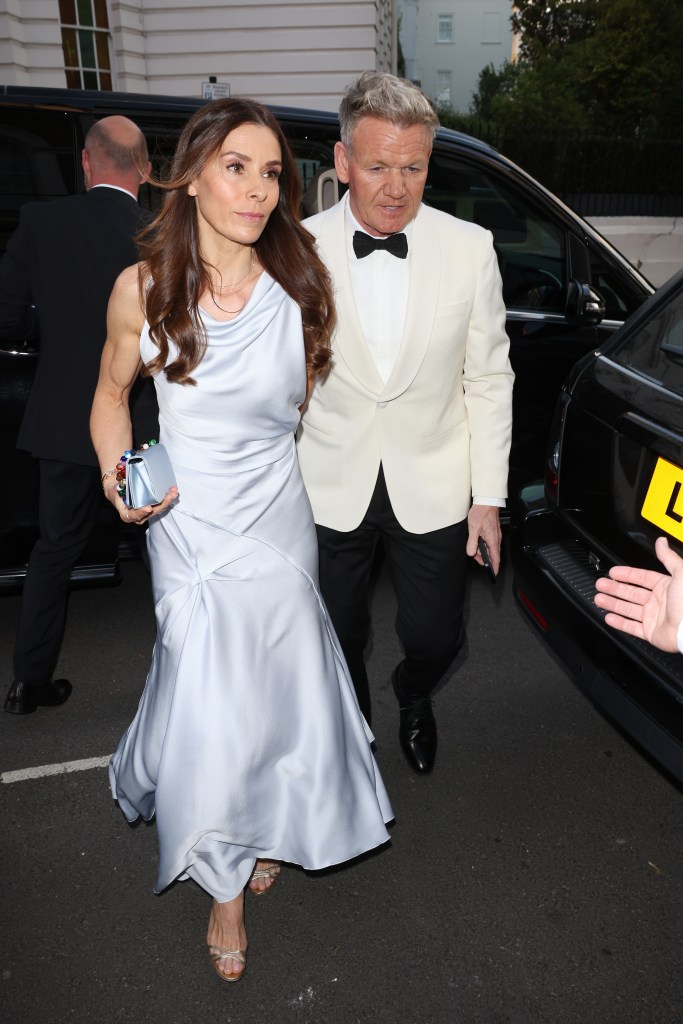 Gordon Ramsay in a white tuxedo jacket, white shirt and black bow ties and black pants. Tana Ramsay in a grey satin gown.