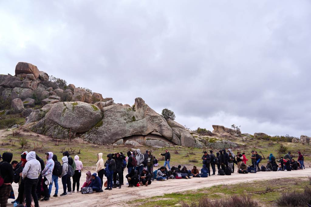 Migrants surrendered to U.S. Customs and Border Protection officers at a makeshift migrant camp after they crossed the U.S.-Mexico border on Wednesday, February 21, 2024 in Boulevard, California.