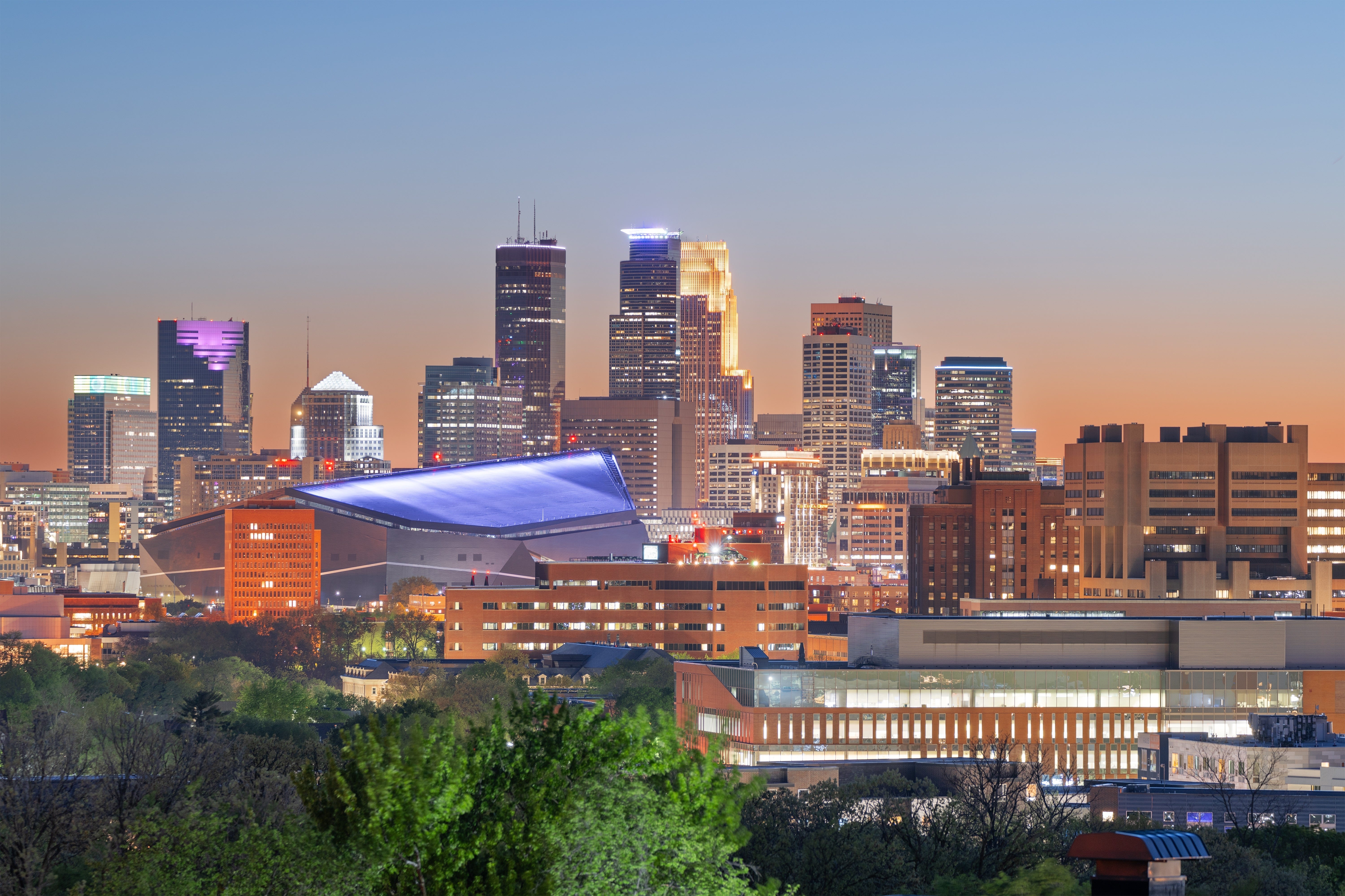 Downtown Minneapolis skyline at dusk with US Bank Stadium in view.