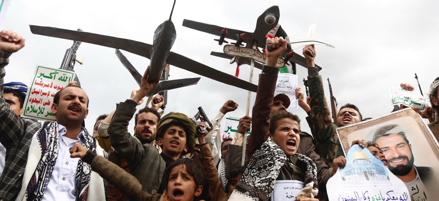 Yemenis brandish weapons, mock drones, and chant slogans during a mass protest against U.S. airstrikes, which have reportedly killed civilians, and in solidarity with people in the Gaza Strip on May 2, 2025, in Sana'a, Yemen