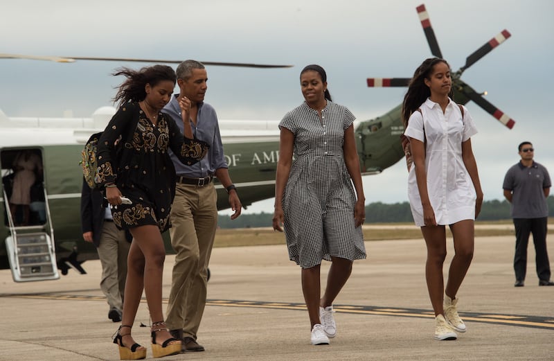 US President Barack Obama, First Lady Michelle Obama and daughters Malia and Sasha walk to board Air Force One at Cape Cod Air Force Station in Massachusetts on August 21, 2016 as they depart for Washington after a two-week holiday at nearby Martha's Vineyard. / AFP / NICHOLAS KAMM (Photo credit should read NICHOLAS KAMM/AFP via Getty Images)