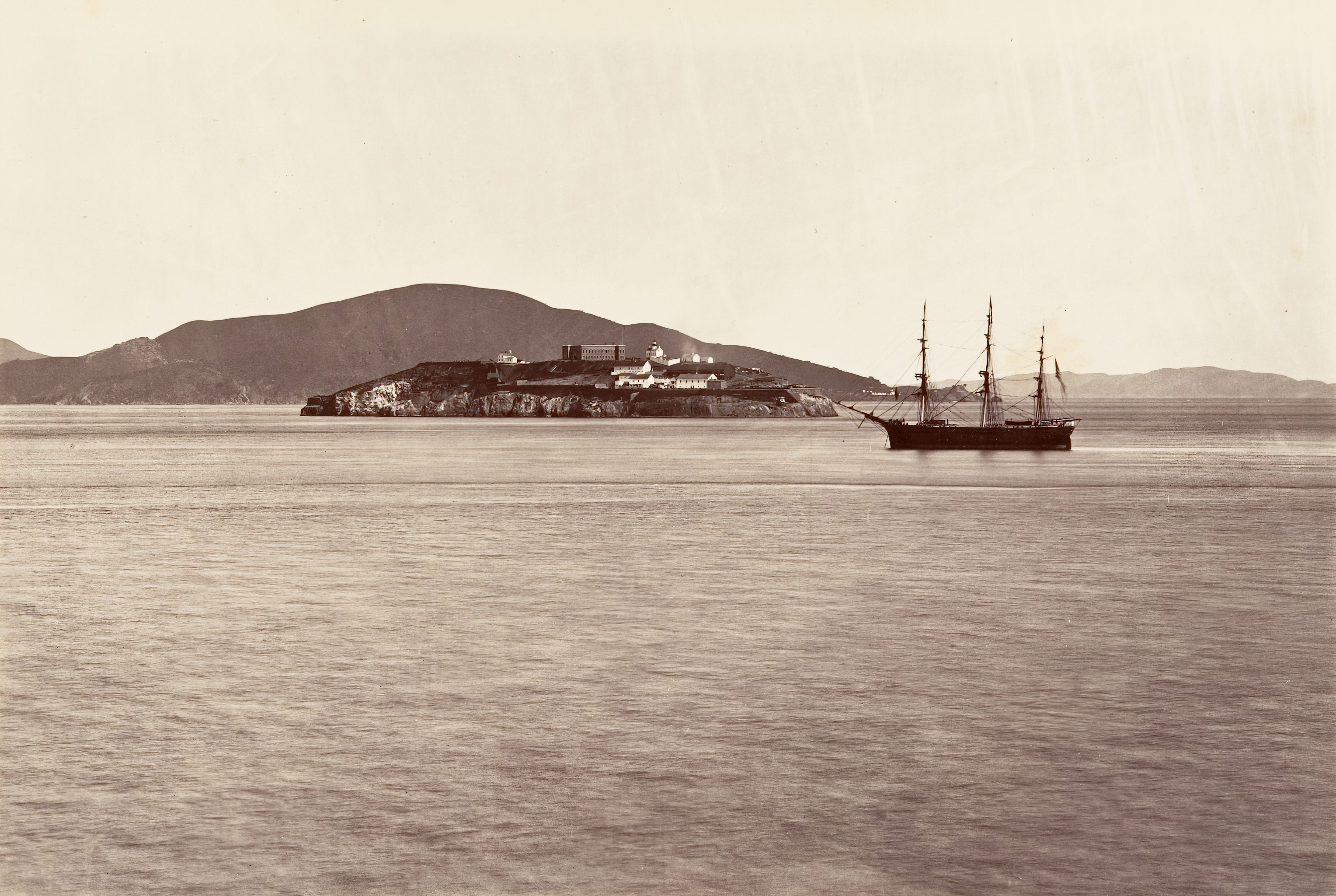 A three-mast boat in front of an island