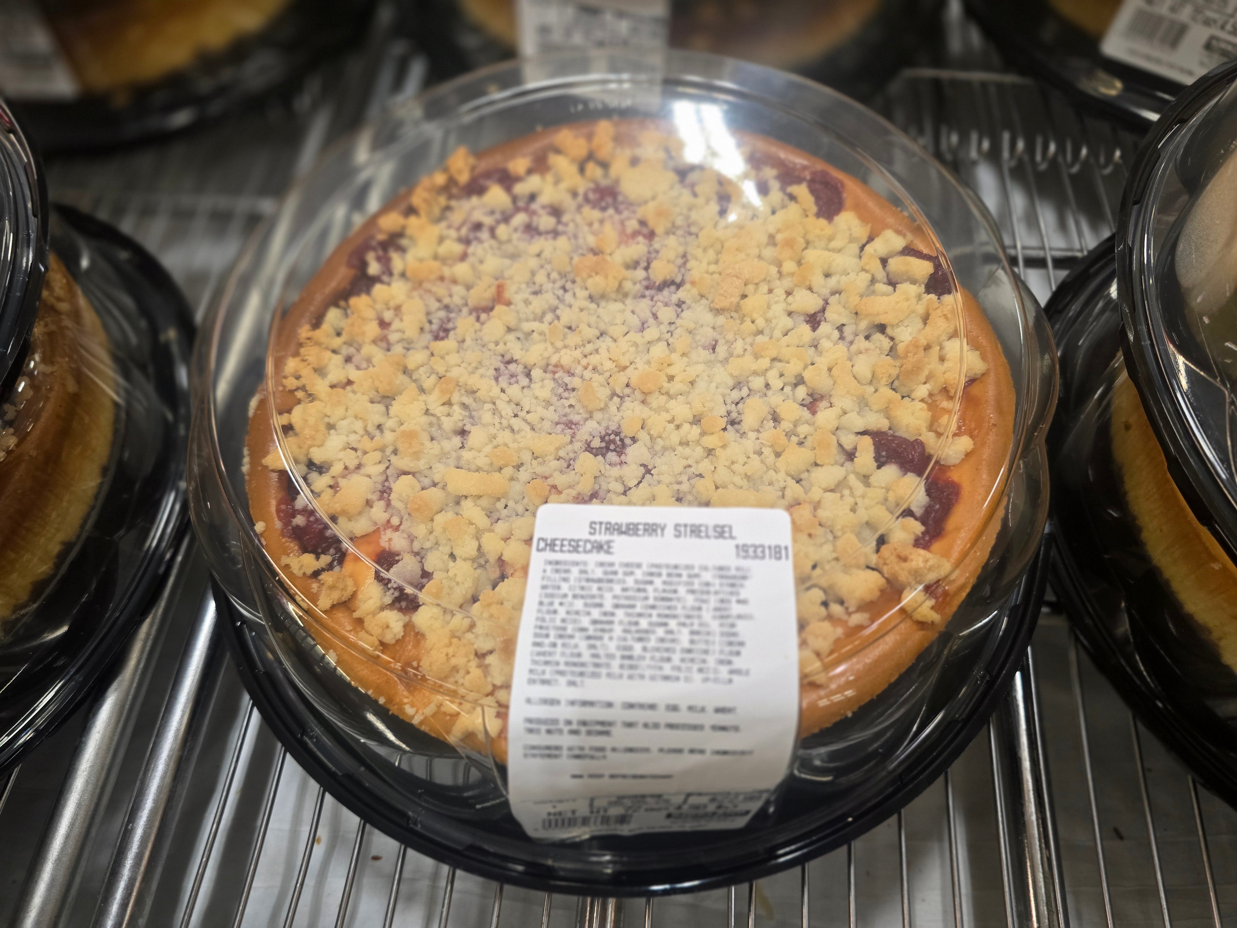 A strawberry streusel cheesecake in a plastic container.