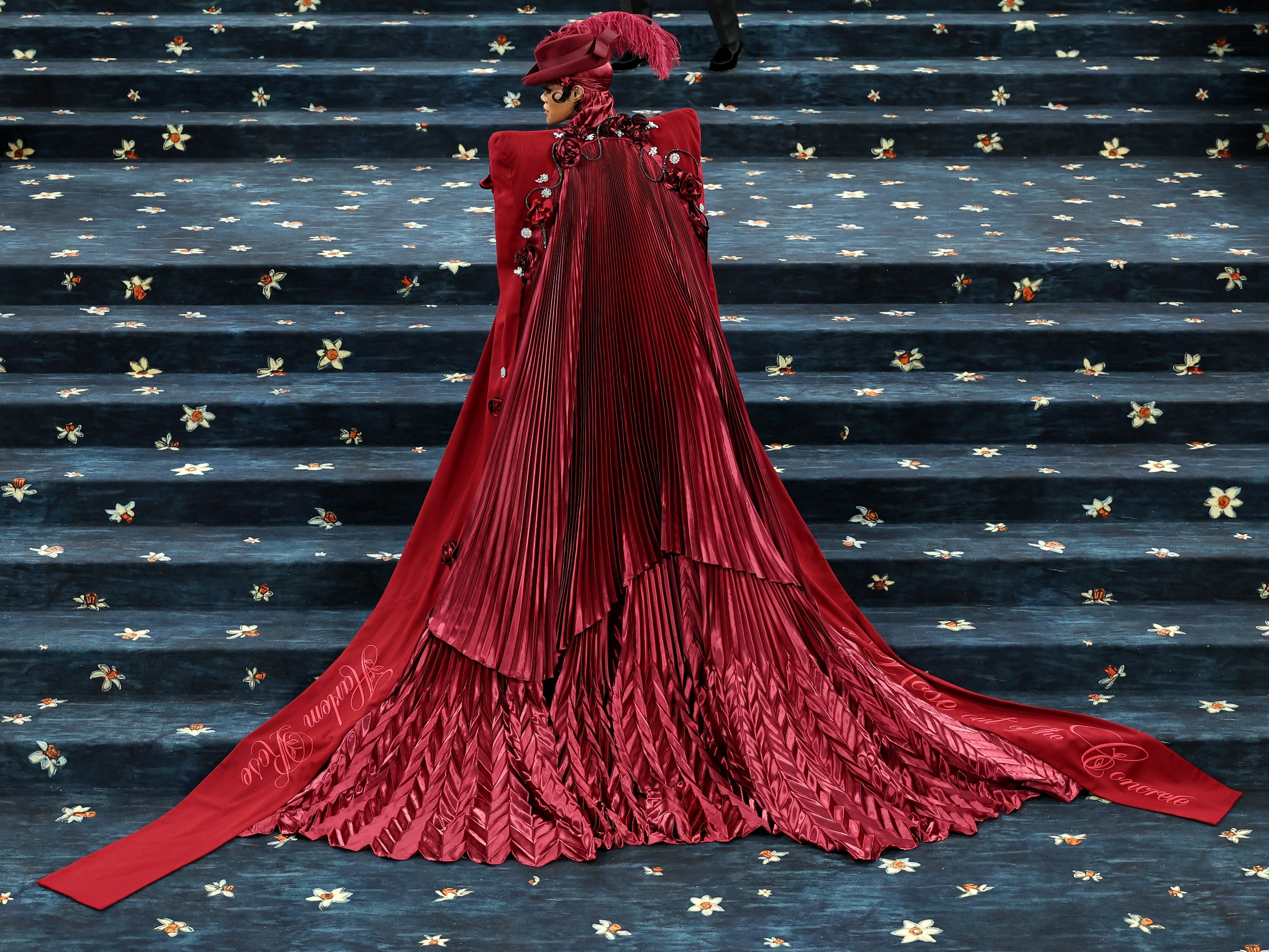 Teyana Taylor walks the Met Gala red carpet while her pleated jacket flows behind her.