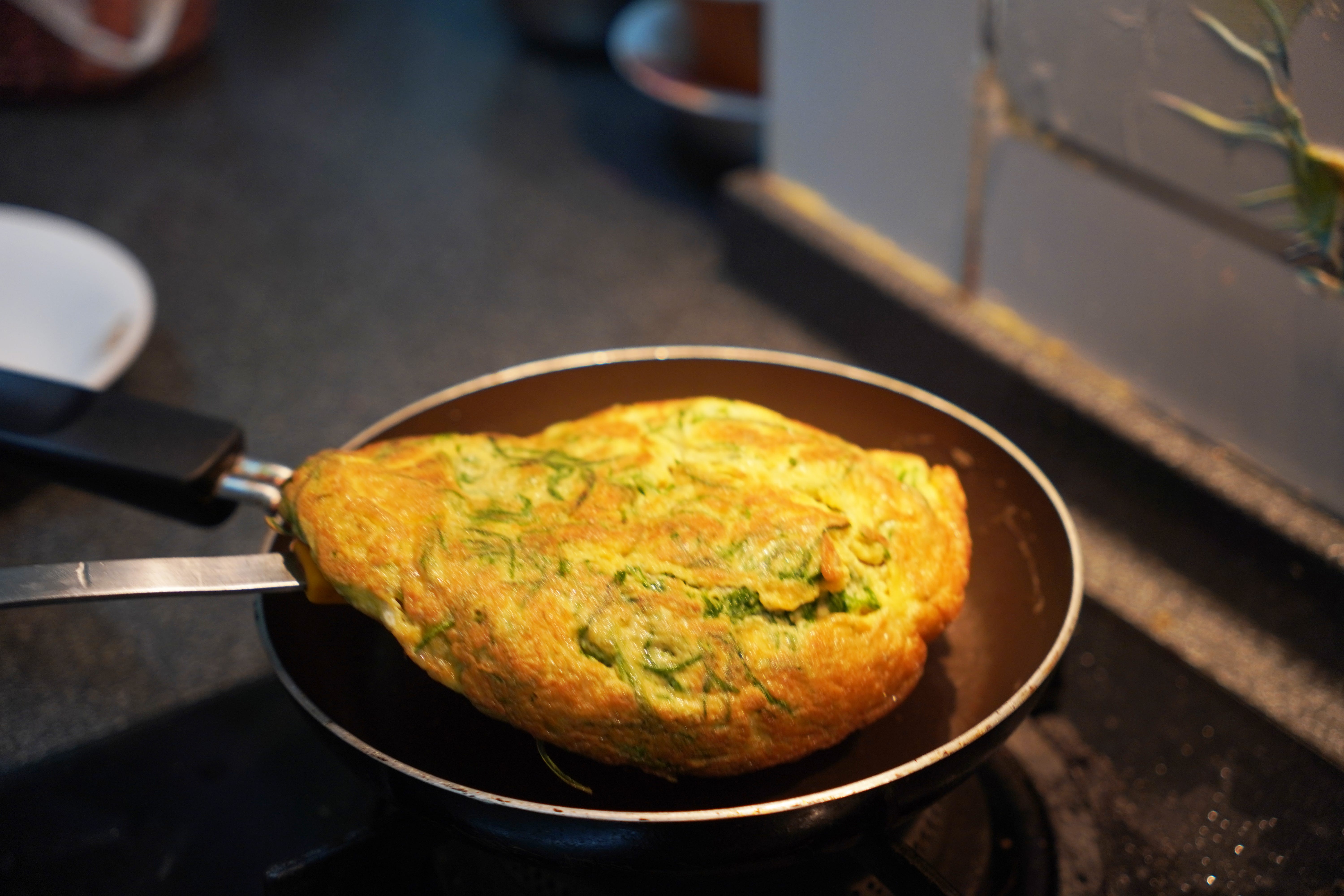 Omelet with herbs in it on a pan