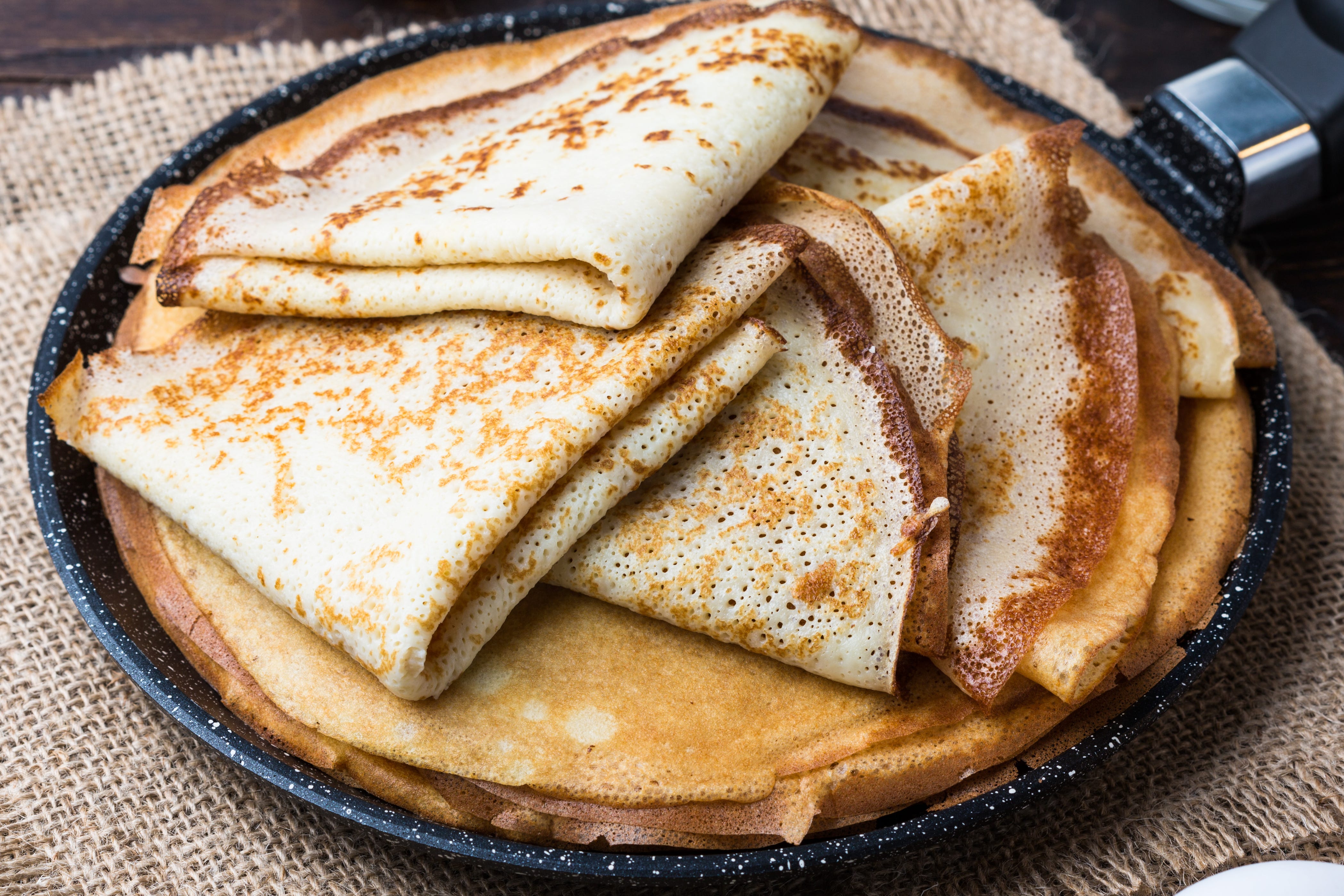 Stack of folded crepes on pan
