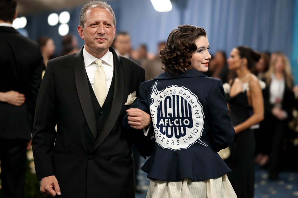 Brad Lander and daughter Rosa Lander pose at the Met Gala, Rosa is wearing a jacket with a union logo on the back.