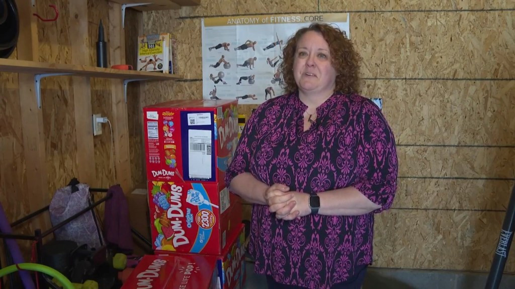 Holly LaFavers stands next to several of the boxes of lollipops during an interview.